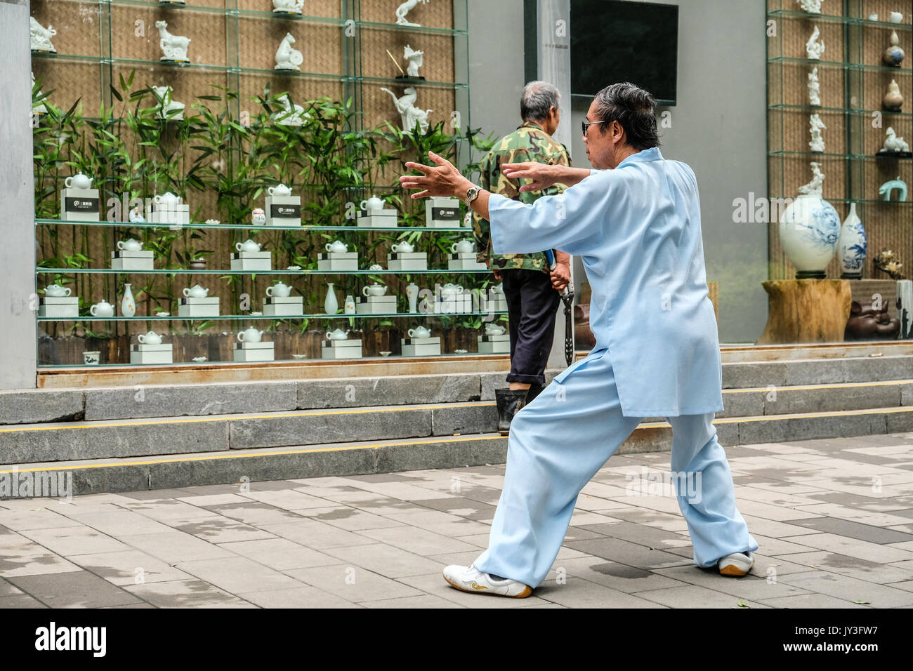 Ein chinesischer Mann in der Traditionellen Chinesischen dressing üben Tai Ji im Yu Yuan Tan Park in Peking, China Stockfoto