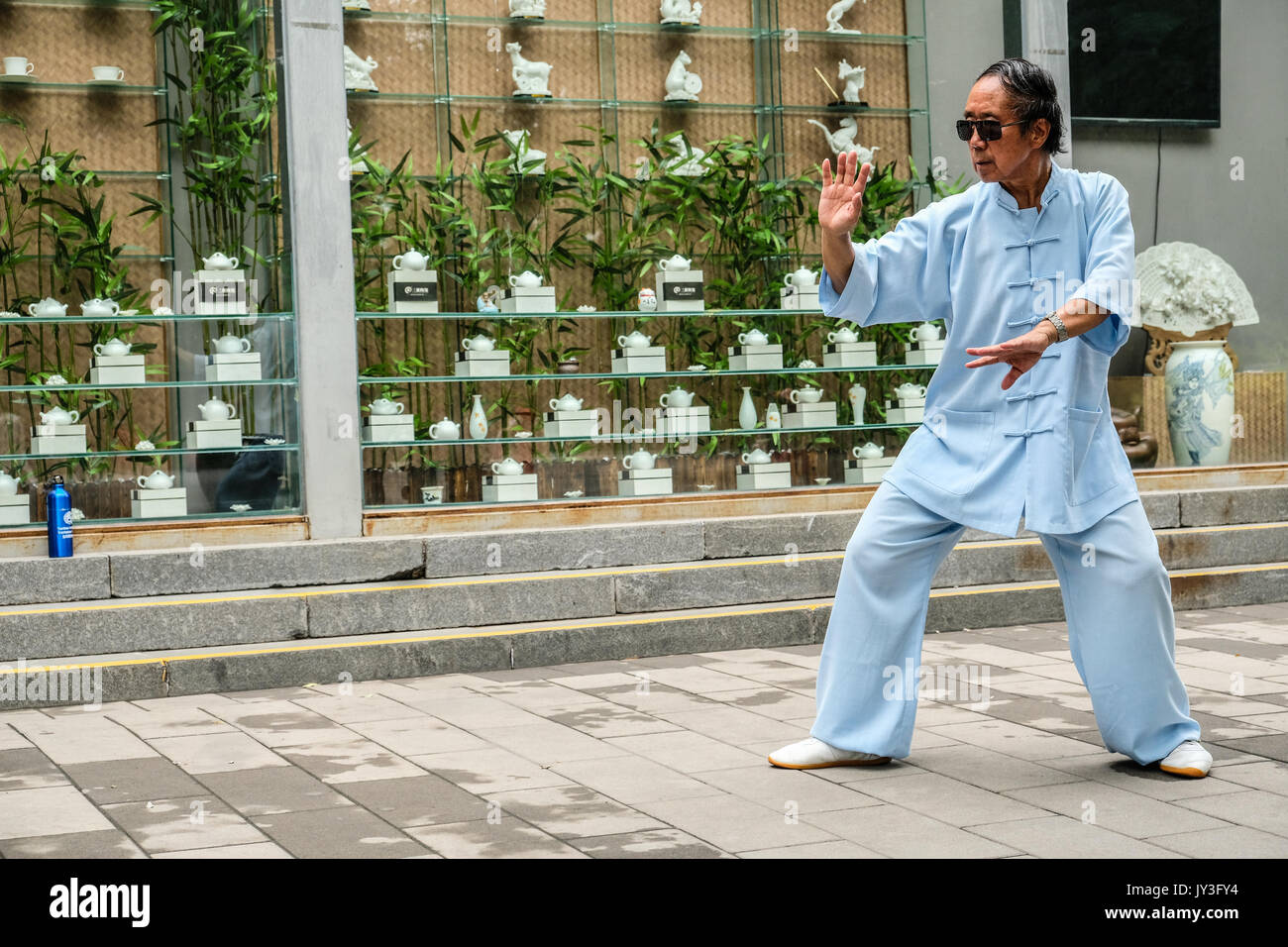 Ein chinesischer Mann in der Traditionellen Chinesischen dressing üben Tai Ji im Yu Yuan Tan Park in Peking, China Stockfoto