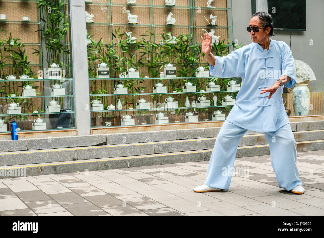 Ein chinesischer Mann in der Traditionellen Chinesischen dressing üben Tai Ji im Yu Yuan Tan Park in Peking, China Stockfoto