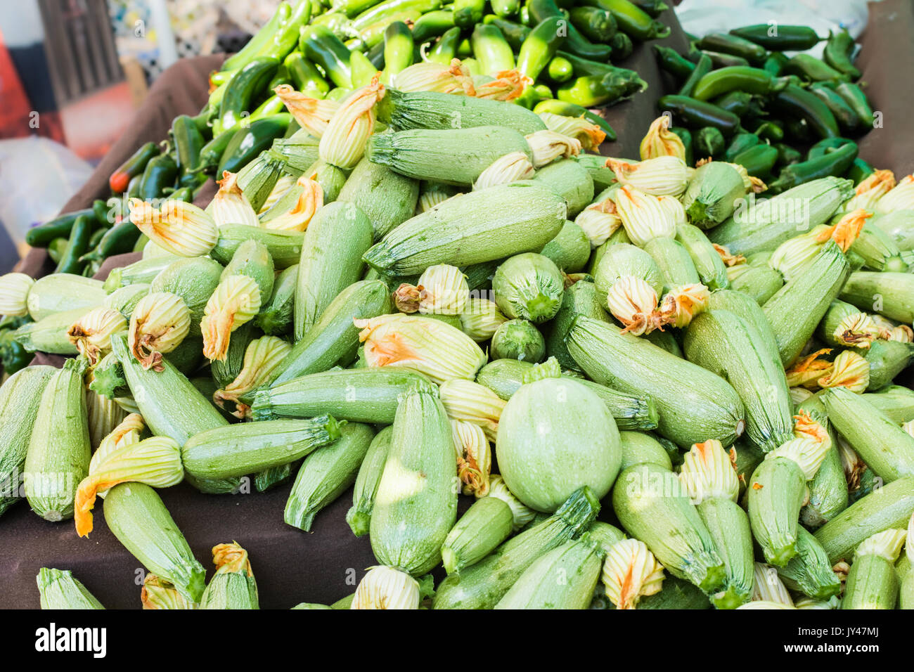 Ein Haufen Grüne Zucchini und Paprika mounded nach oben auf einem Tisch zu einem Bauernmarkt Obst stehen. Stockfoto