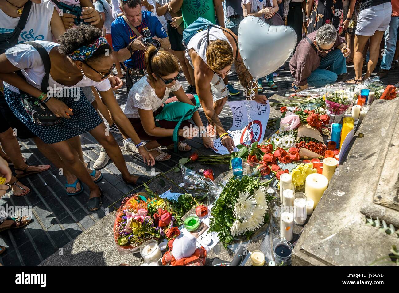 Barcelona, Spanien. 18 Aug, 2017. Ein trauernder Orte eine Kerze in einer provisorischen Denkmal am Anfang von Las Ramblas, wo ein Van eine 550 Meter lange dschihadistischen Terror Reise begann. 13 Tote und fast 80 Verletzte, 15 ernst, als der van Riss durch die Menge der Credit: Matthias Oesterle/Alamy leben Nachrichten Stockfoto