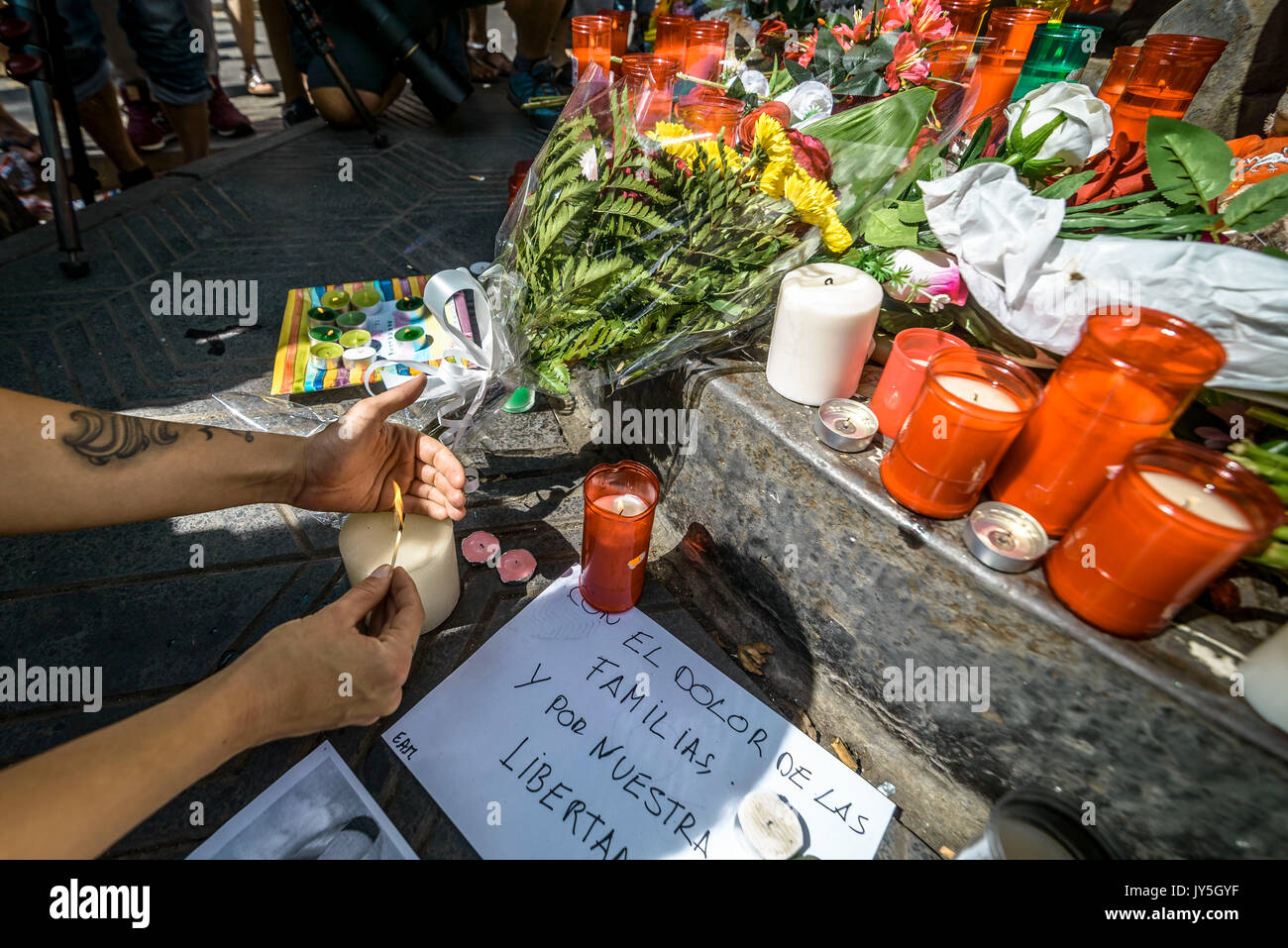 Barcelona, Spanien. 18 Aug, 2017. Ein trauernder Orte eine Kerze in einer provisorischen Denkmal in Las Ramblas, wo ein Van eine 550 Meter lange dschihadistischen Terror Reise lief. 13 Tote und fast 80 Verletzte, 15 ernst, als der van Riss durch die Menge der Credit: Matthias Oesterle/Alamy leben Nachrichten Stockfoto