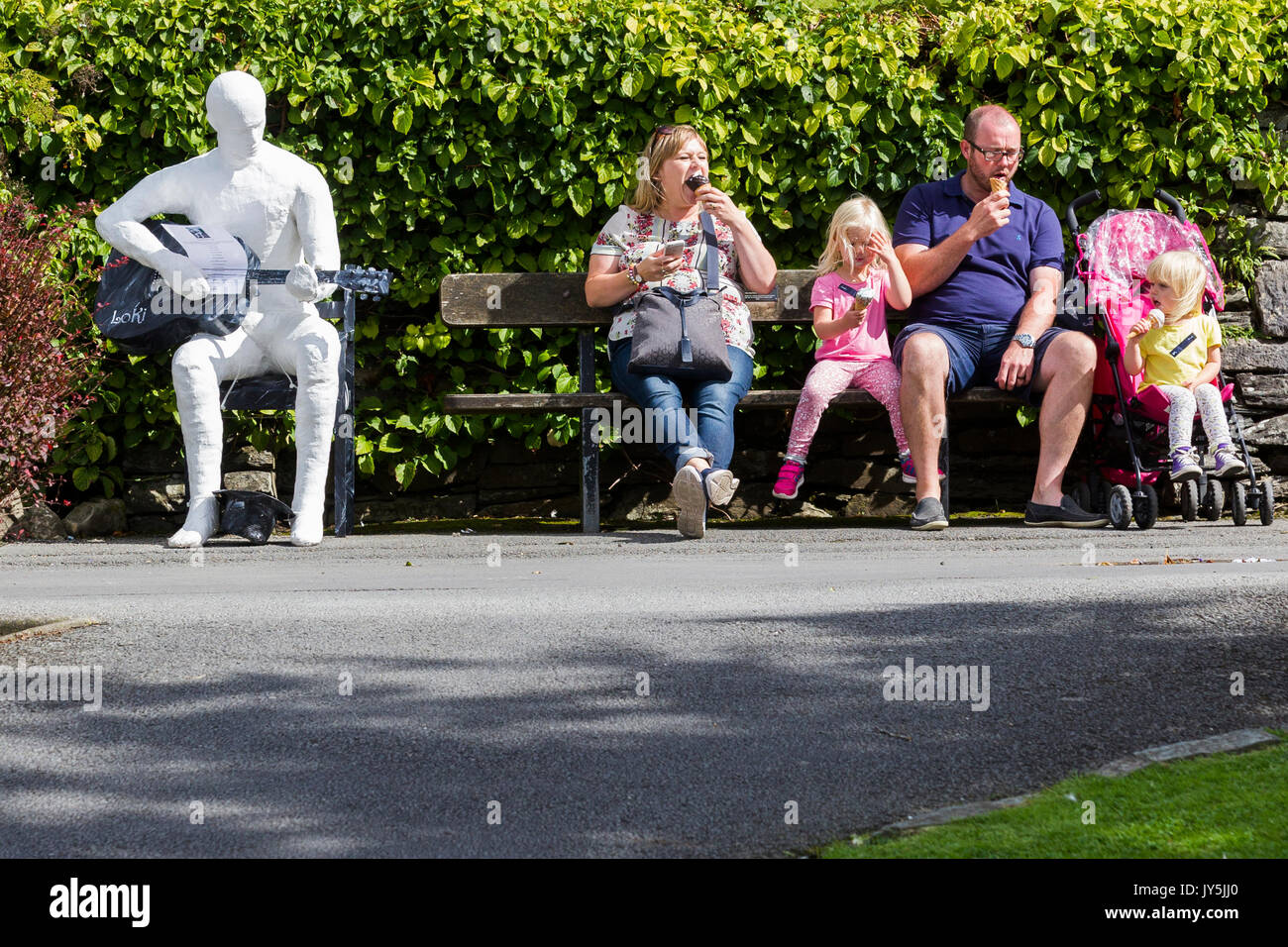 Cumbria, Großbritannien. 18 Aug, 2017. Lake Windermere im Lake District, Cumbria. Bowness Bay Front. Statue von mysteriösen Artist Loki? "Ulverston Banksys' Geld für die lokale "food bank". Statuen haben sich rund um den Bereich poped, darunter St. Martins Kirche, Bowness. Credit: Gordon Shoosmith/Alamy Live News Credit: Gordon Shoosmith/Alamy leben Nachrichten Stockfoto