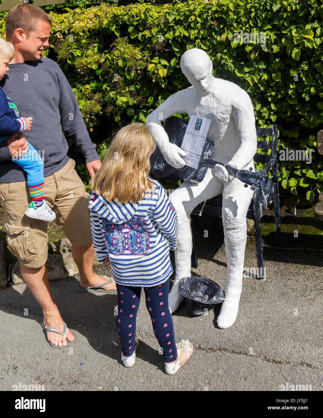 Cumbria, Großbritannien. 18 Aug, 2017. Lake Windermere im Lake District, Cumbria. Bowness Bay Front. Statue von mysteriösen Artist Loki? "Ulverston Banksys' Geld für die lokale "food bank". Statuen haben sich rund um den Bereich poped, darunter St. Martins Kirche, Bowness. Credit: Gordon Shoosmith/Alamy Live News Credit: Gordon Shoosmith/Alamy leben Nachrichten Stockfoto