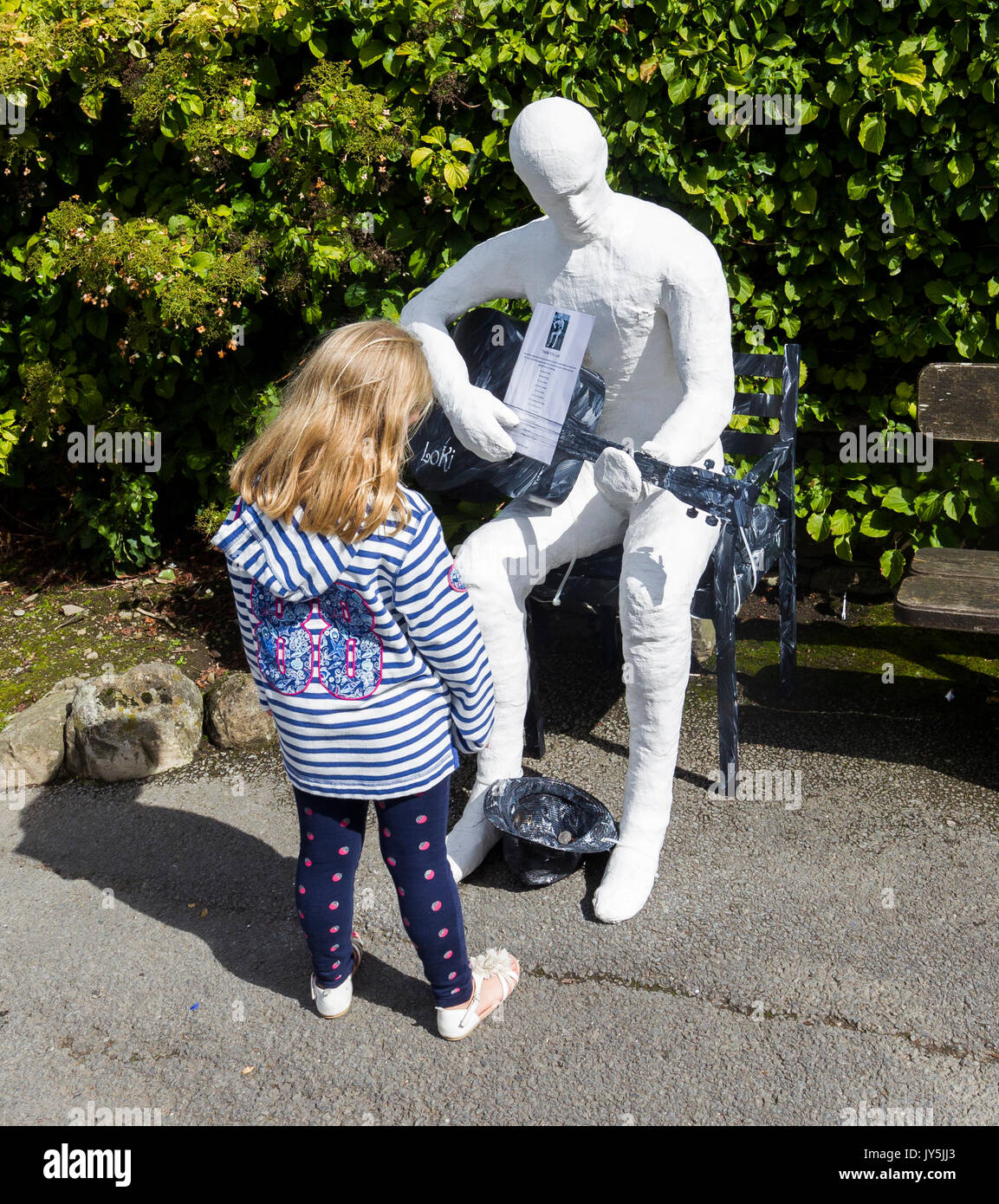 Cumbria, Großbritannien. 18 Aug, 2017. Lake Windermere im Lake District, Cumbria. Bowness Bay Front. Statue von mysteriösen Artist Loki? "Ulverston Banksys' Geld für die lokale "food bank". Statuen haben sich rund um den Bereich poped, darunter St. Martins Kirche, Bowness. Credit: Gordon Shoosmith/Alamy Live News Credit: Gordon Shoosmith/Alamy leben Nachrichten Stockfoto