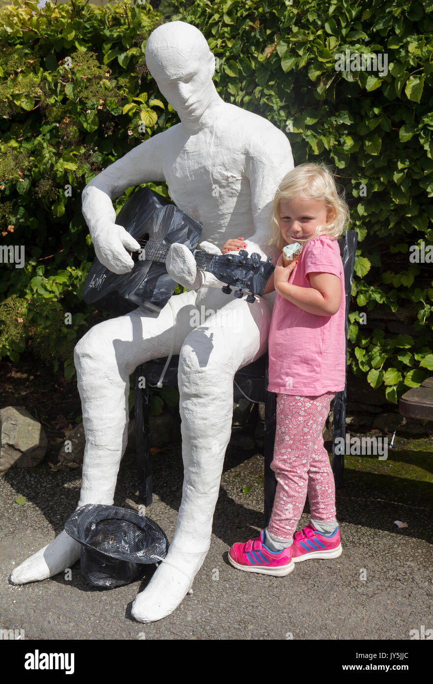 Cumbria, Großbritannien. 18 Aug, 2017. Lake Windermere im Lake District, Cumbria. Bowness Bay Front. Statue von mysteriösen Artist Loki? "Ulverston Banksys' Geld für die lokale "food bank". Statuen haben sich rund um den Bereich poped, darunter St. Martins Kirche, Bowness. Credit: Gordon Shoosmith/Alamy Live News Credit: Gordon Shoosmith/Alamy leben Nachrichten Stockfoto