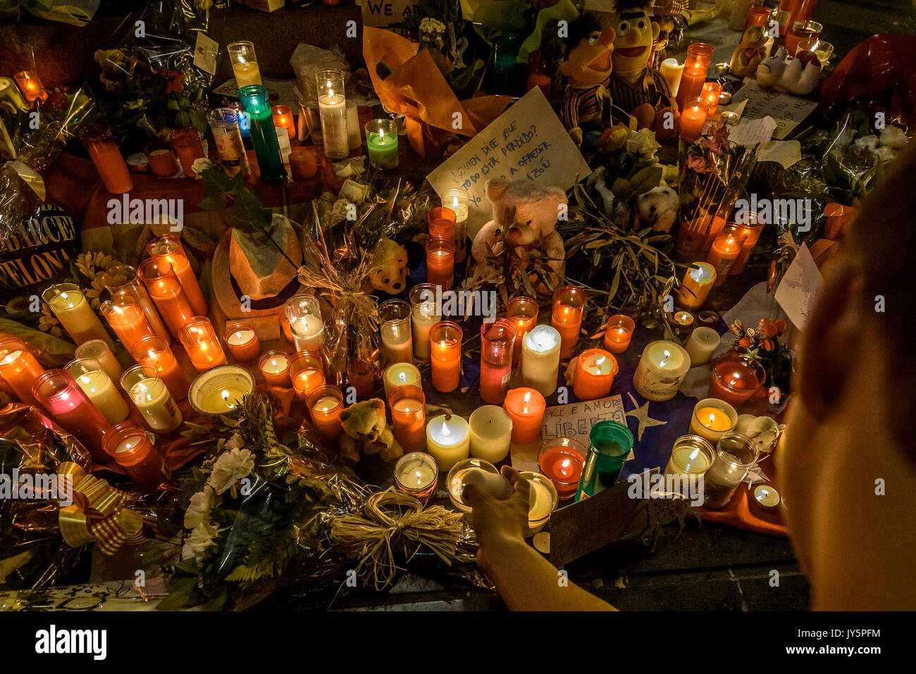 Barcelona, Spanien. 18 Aug, 2017. Ein trauernder Orte eine Kerze in einer provisorischen Denkmal am Anfang von Las Ramblas, wo ein Van eine 550 Meter lange dschihadistischen Terror Reise begann. 13 Tote und fast 80 Verletzte, 15 ernst, als der van Riss durch die Menge der Credit: Matthias Oesterle/Alamy leben Nachrichten Stockfoto