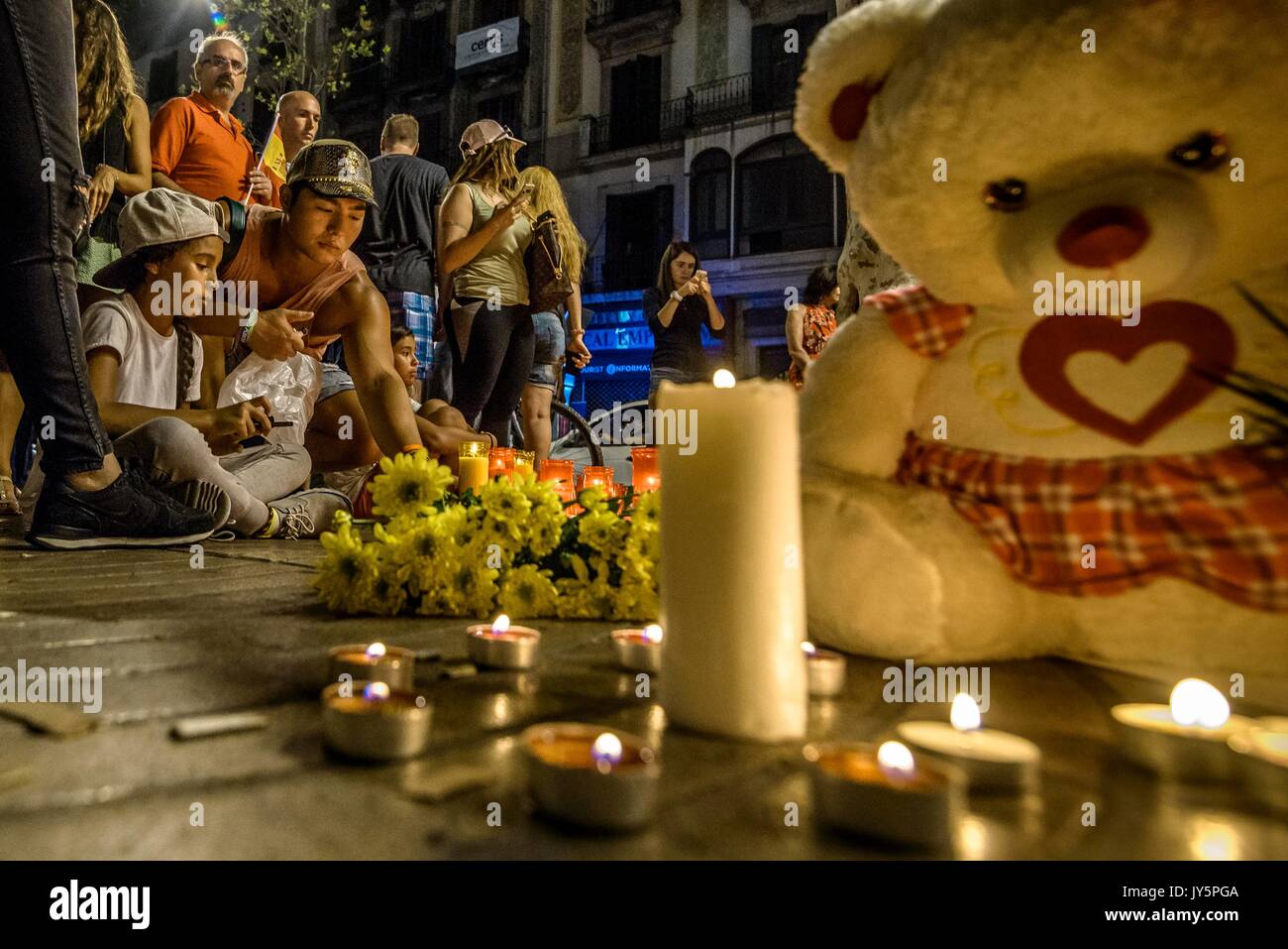 Barcelona, Spanien. 18 Aug, 2017. Ein trauernder Orte eine Kerze in einer provisorischen Denkmal an der Canaletas Brunnen in Las Ramblas, wo ein Van eine 550 Meter lange dschihadistischen Terror Reise gemacht. 13 Tote und fast 80 Verletzte, 15 ernst, als der van Riss durch die Menge der Credit: Matthias Oesterle/Alamy leben Nachrichten Stockfoto