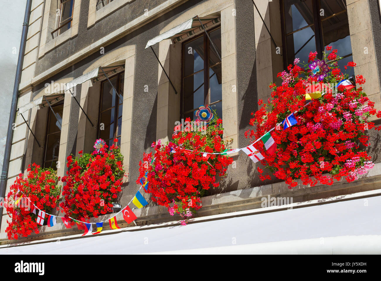 Vintage Fenster mit Blumen und Fahnen, Genf, Schweiz Stockfoto