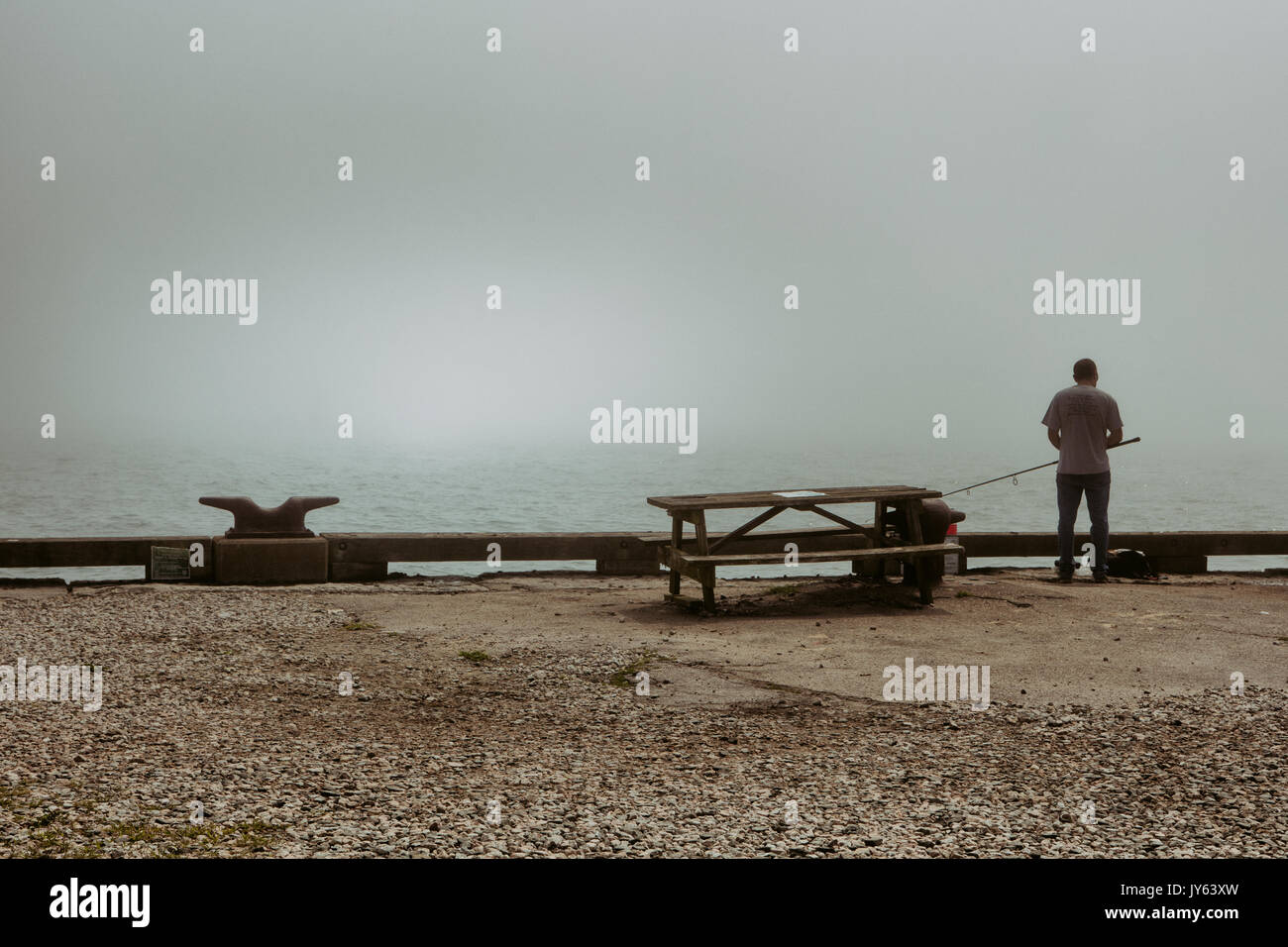 Ein einsamer Fischer auf den Docks am Fort Wetherill in Jamestown, RI. Stockfoto