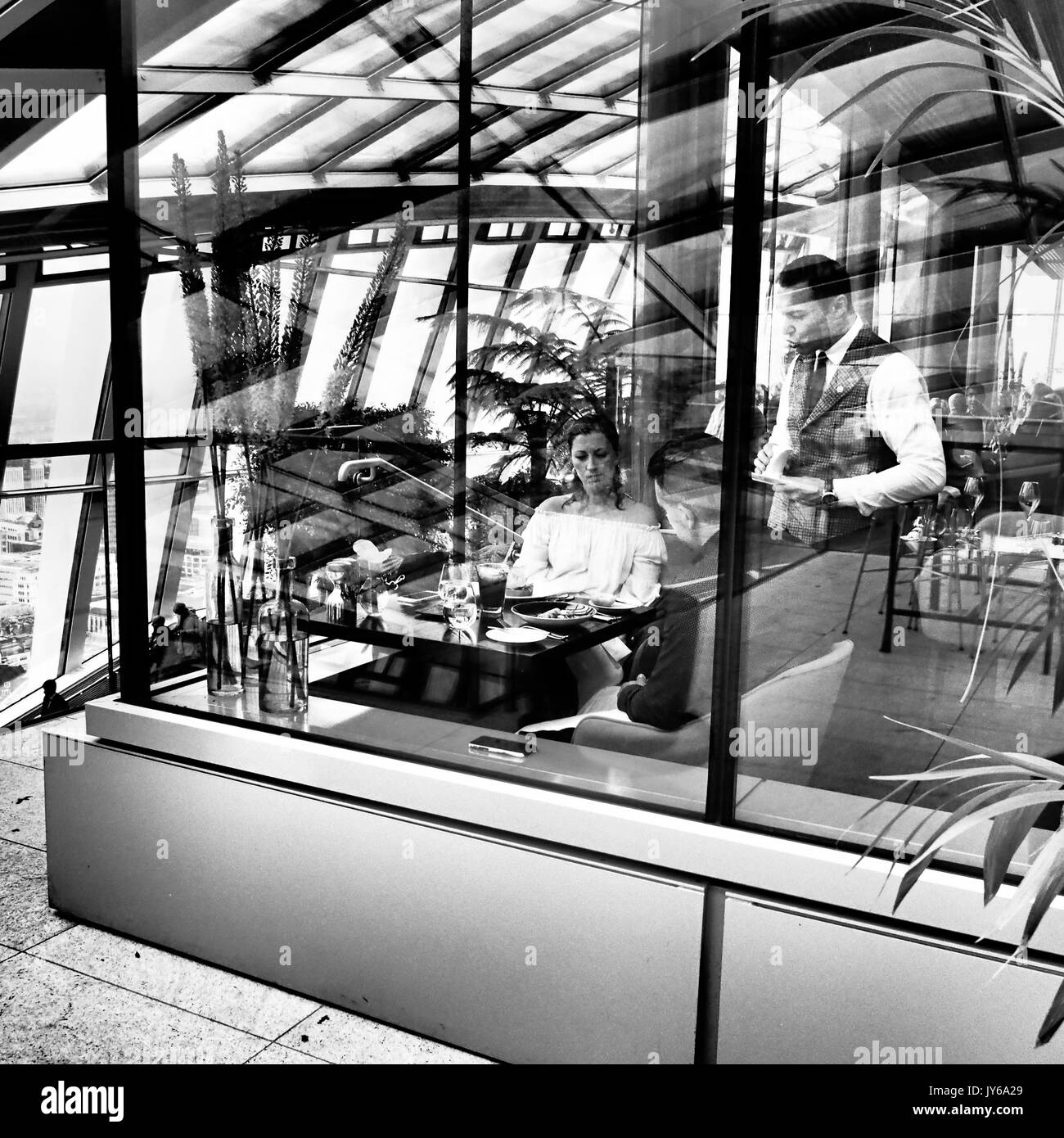 Paar wird in einem Restaurant in der Sky Garden, Walkie Talkie Wolkenkratzer, London serviert. Stockfoto