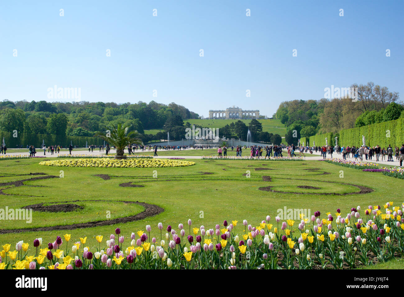 Wien, ÖSTERREICH - Apr 30th, 2017: Neptunbrunnen Neptunbrunnen im Großen Parterre von Schönbrunn öffentlichen Park mit Blumen im Vordergrund und die Gloriette im Rücken, Schloss Schönbrunn - ehemalige kaiserliche Sommerresidenz, gebaut und während der Regentschaft von Kaiserin Maria Theresia im Jahre 1743 renoviert Stockfoto