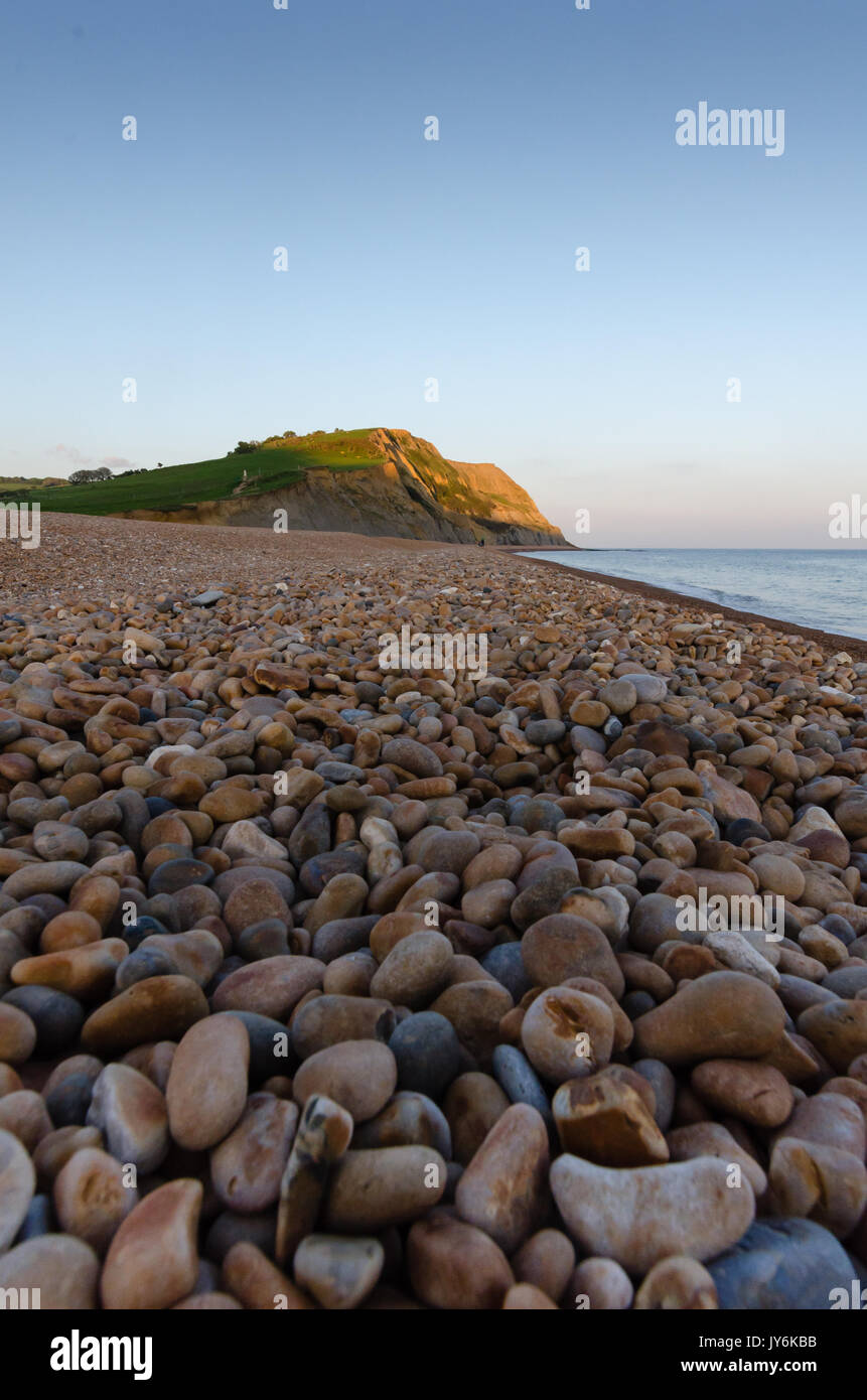 Kiesstrand an Seatown, Dorset, in der Dämmerung, mit Klippen in der Ferne leuchtet durch die letzte der Abendsonne Stockfoto