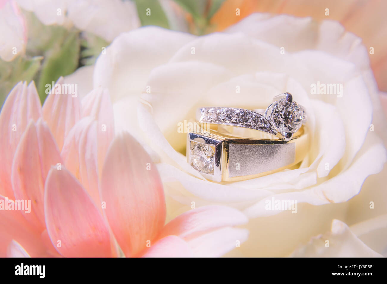 Zwei Trauringe auf Blumenstrauß Stockfoto