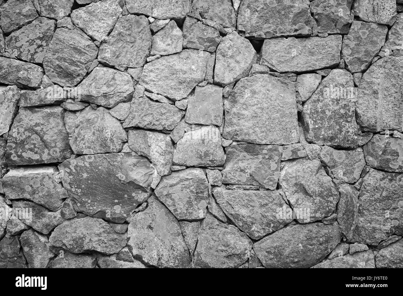 Alte Mauer in eine Festung aus Stein mit Flechten in Schwarz und Weiß. Stockfoto