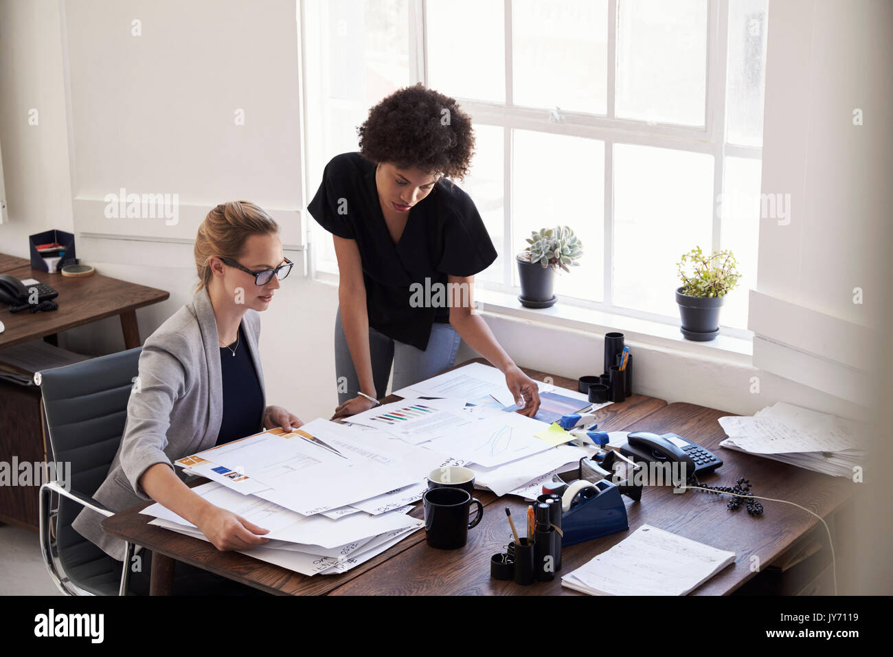 Zwei junge Unternehmerinnen Studium Dokumente in einem Büro Stockfoto