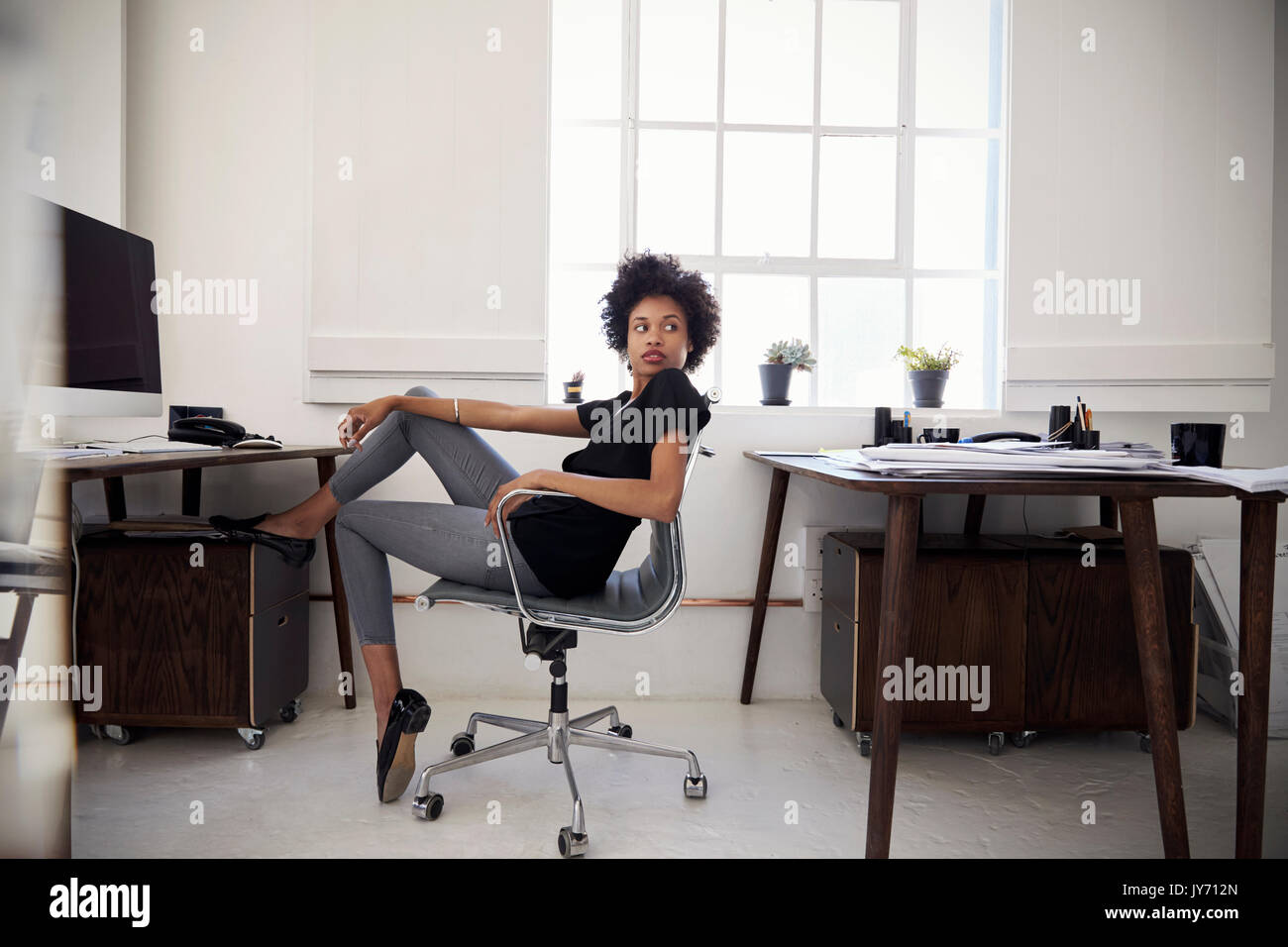 Junge Geschäftsfrau sitzt in einem Büro über die Schulter schauen Stockfoto