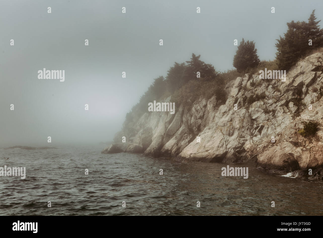 Nebel umhüllt die felsigen Klippen am Fort Wetherill in Jamestown, RI. Stockfoto