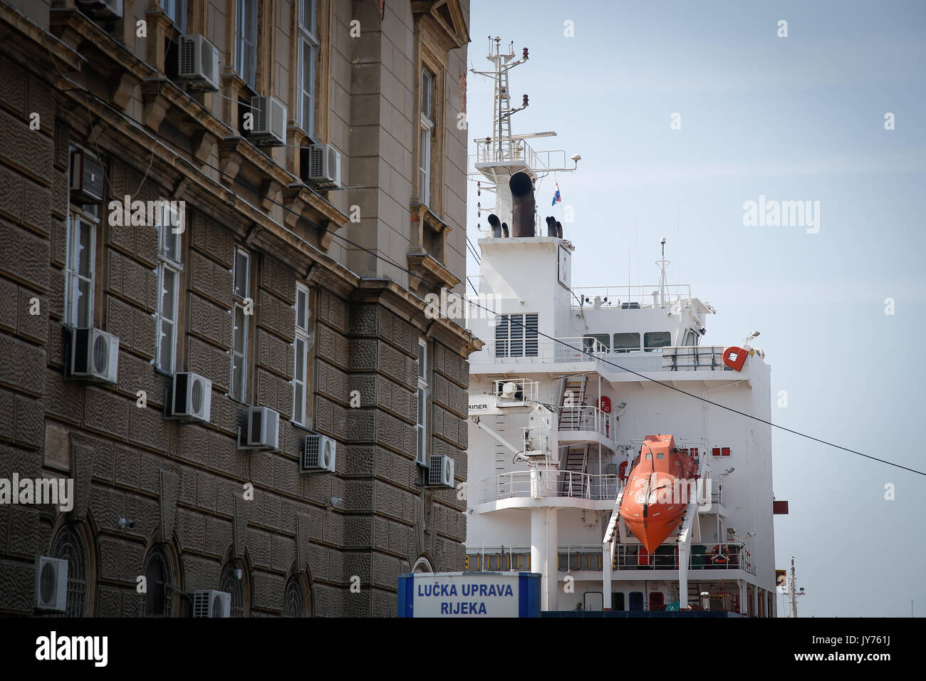 Ein cargo Schiff ist im Hafen von Rijeka hinter einem Gebäude im Zentrum der Stadt am 23. Juli 2017 gesehen. Stockfoto