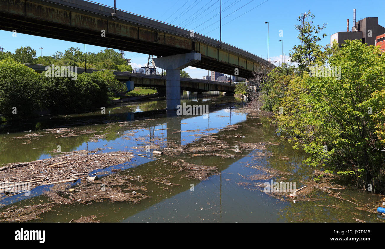 Müll und Schutt dieser Wasserstraße unter einer Überführung verschmutzen. Stockfoto