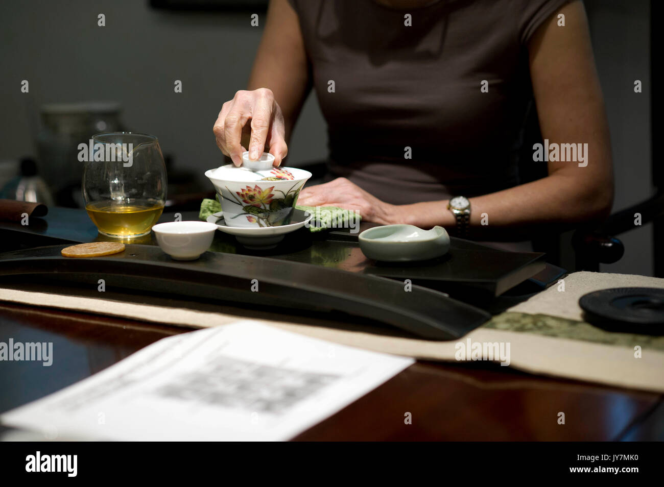 Weibliche brauen Sie grünen Tee in eine Tasse Tee mit Deckel. Stockfoto