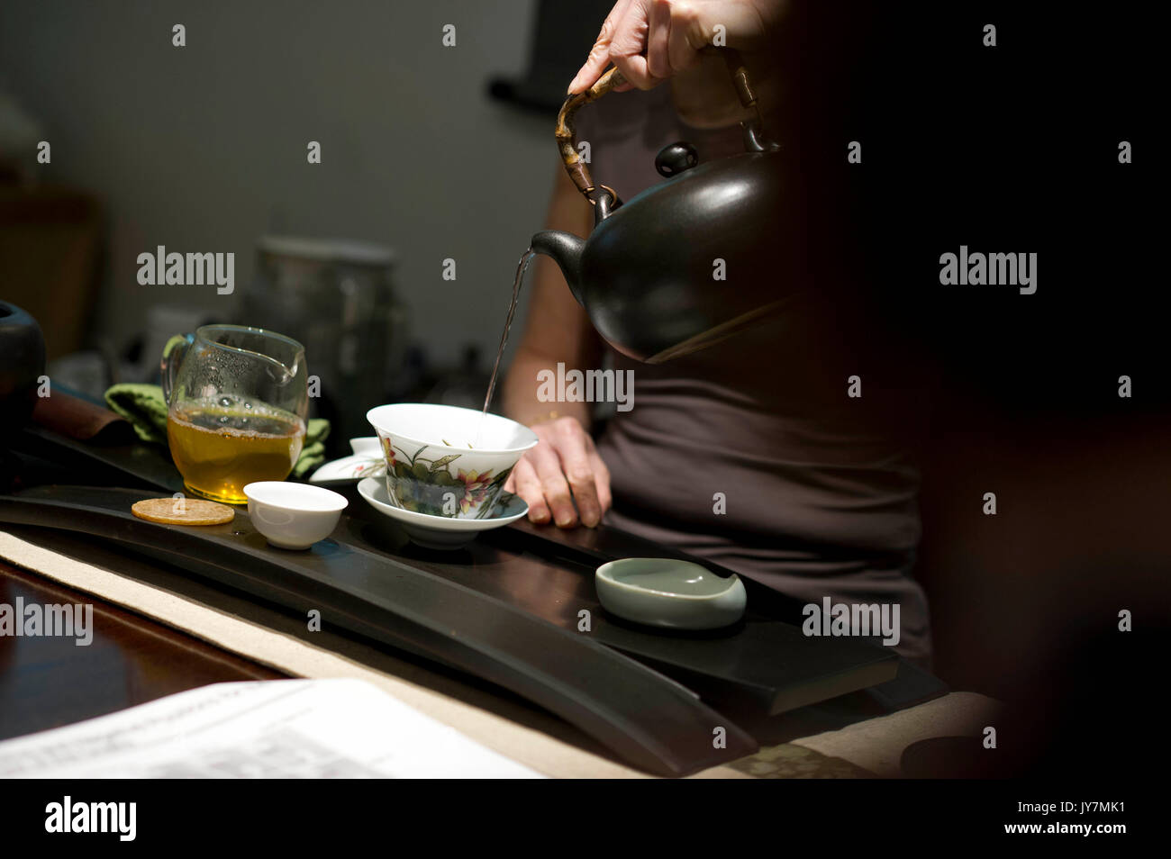 Weibliche brauen Sie grünen Tee in eine Tasse Tee mit Deckel. Stockfoto