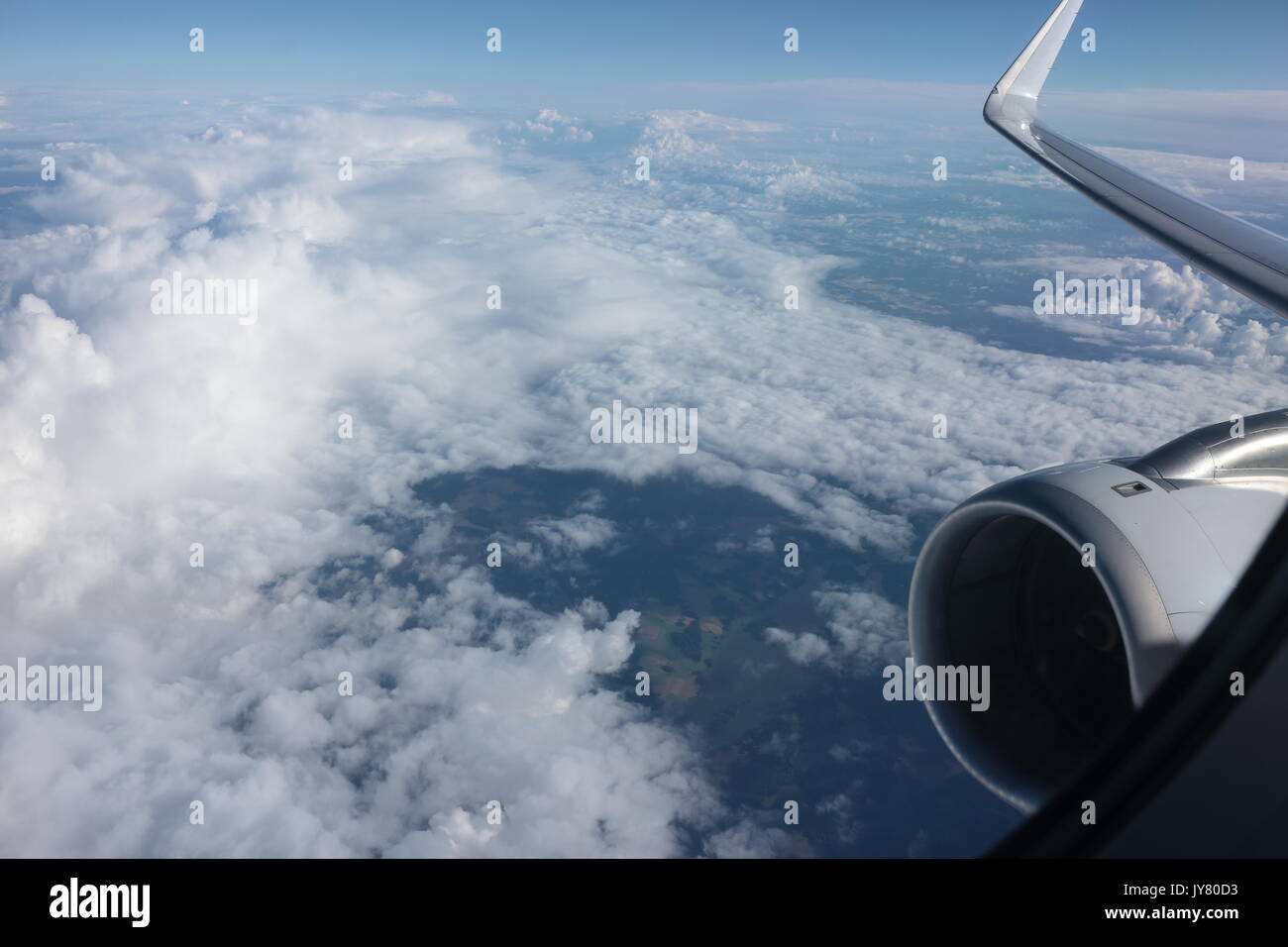 Flugzeug Fenster anzeigen. Blick auf Wolken durch Flugzeug Fenster. Über den Wolken. Flugzeug Fenster mit Blick auf die Wolken und Land vom Beifahrersitz. Ferienhäuser. Stockfoto