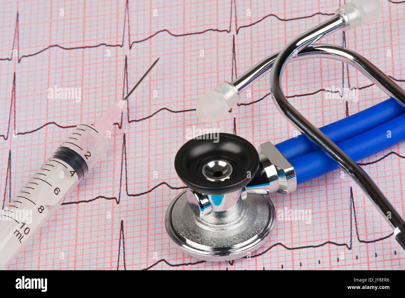 Nahaufnahme von einem Elektrokardiographen auch als einen EKG- oder EKG-Diagramm mit einem Stethoskop und Spritze bekannt Stockfoto