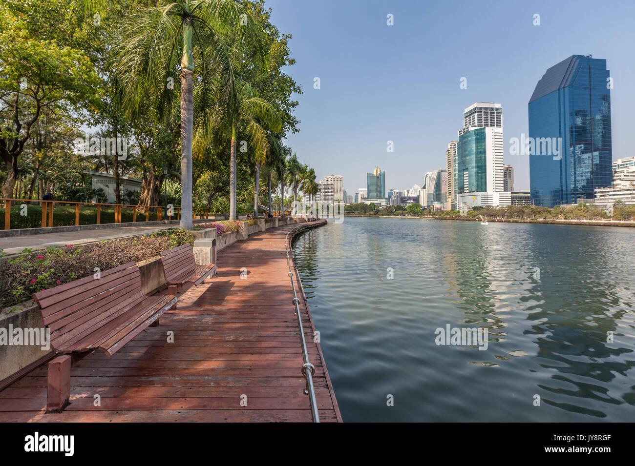 Benjakiti Park in Bangkok, Thailand Skyline mit dem hölzernen Promenade vor dem See Ratchada und Wolkenkratzer Stockfoto