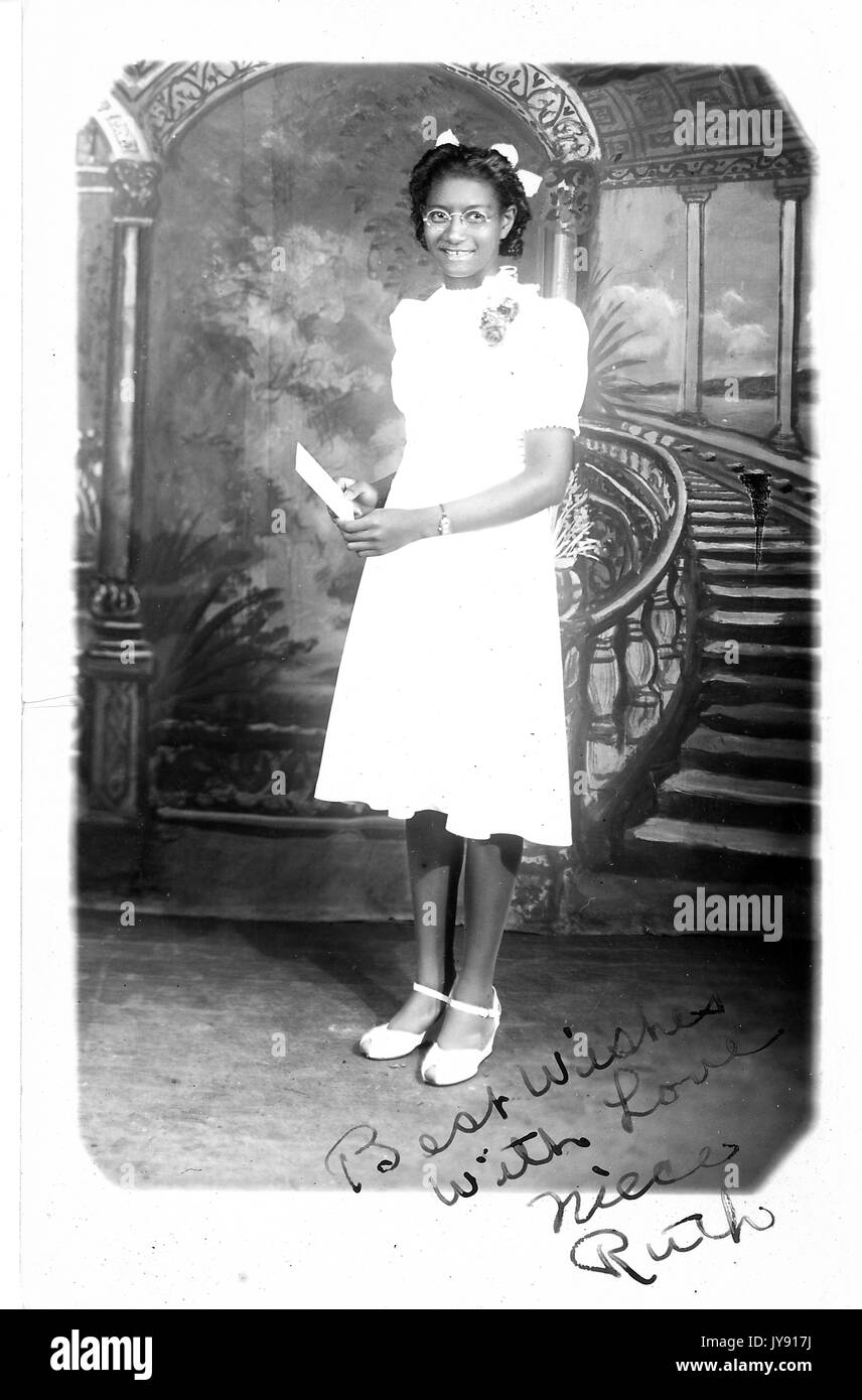 In voller Länge Porträt der jungen Afrikaner - Frau in weiß knielange Kleid, stand vor der Freien, 1920. Stockfoto