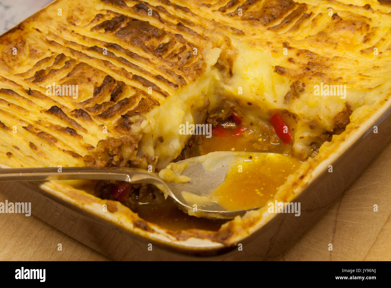 Hausgemachte Cottage Pie mit einem italienischen Stil twist heiß aus dem Ofen mit einem Teil fehlt, mit Hackfleisch, Paprika und Lauch. Stockfoto