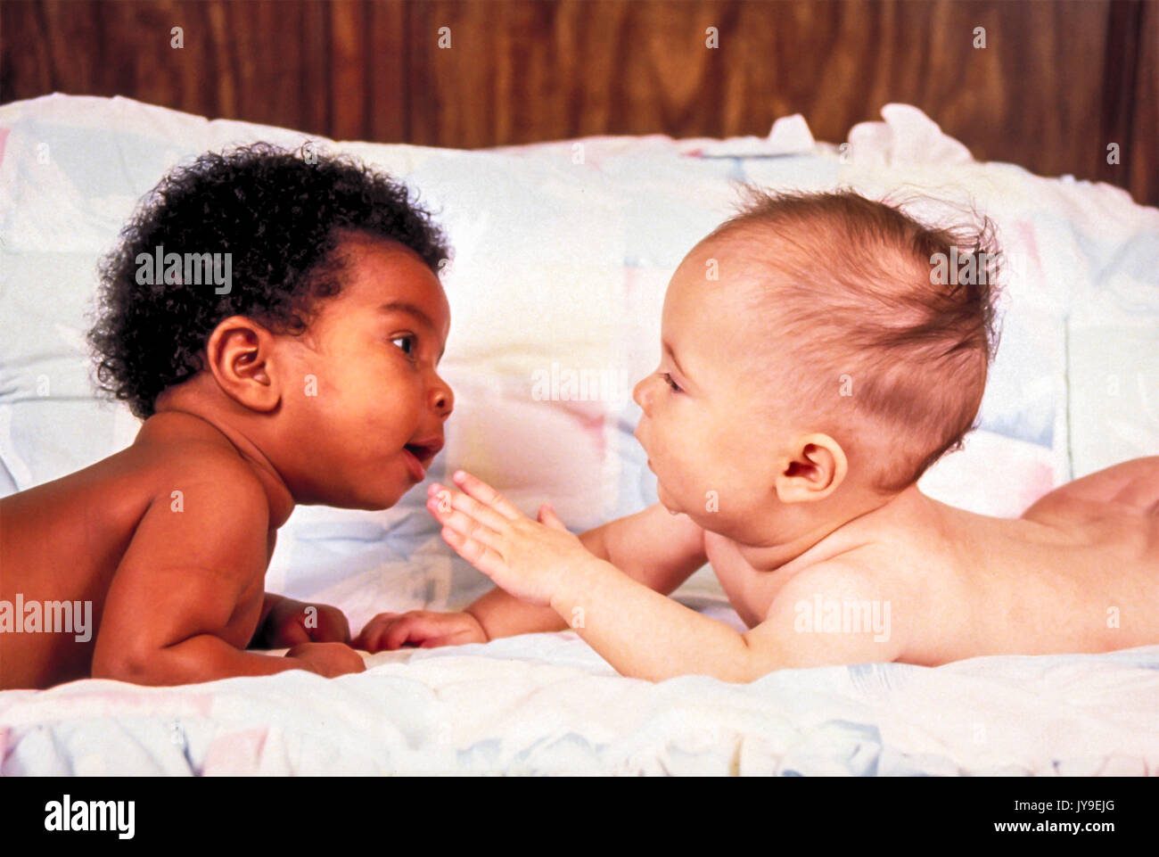 Zwei 2 Babys dunkel helle Haut Magen eng erreichen heraus erreichen, um jede andere neugierige Fragen interracial inter Rasse © Stockfoto