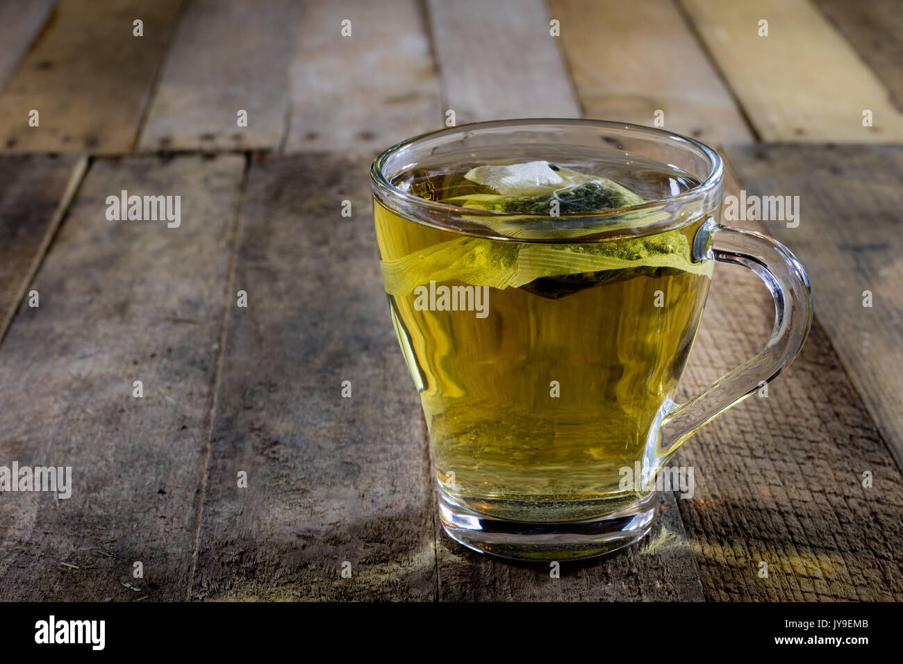 Lecker Kaffee mit Nesseln auf einem Holztisch, schwarzer Hintergrund Stockfoto