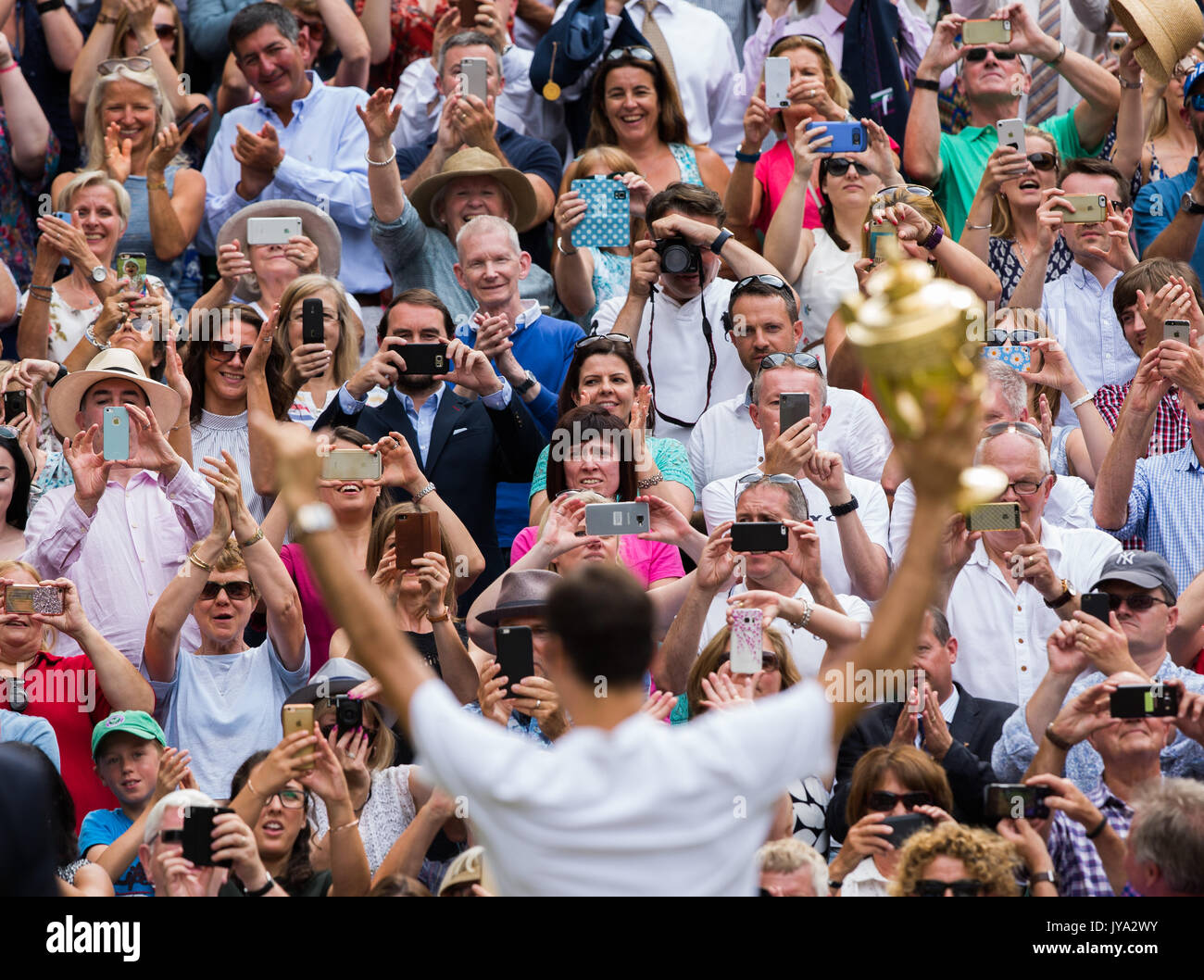 Roger Federer, die Trophäe zu den Zuschauern auf der Tribüne in Wimbledon Stockfoto