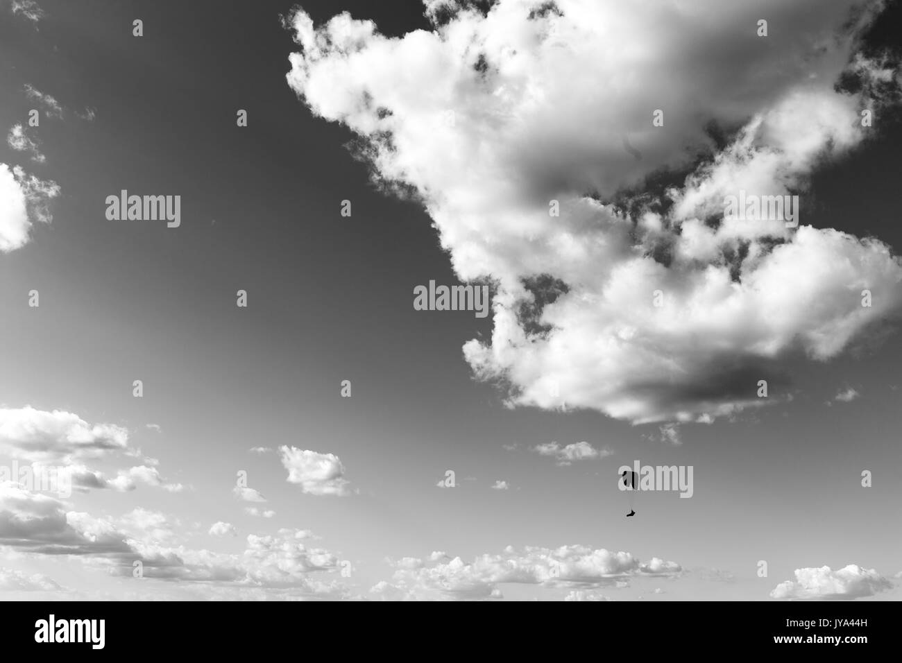 Ein Gleitschirm gegen einen grossen, tiefen Himmel fliegen, mit einigen weißen Wolken Stockfoto