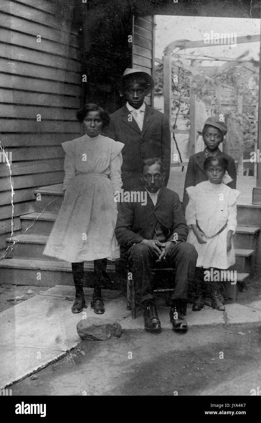 Familie der afrikanisch-amerikanischen Pächter, ein Mann und eine Frau mit ihren drei Kindern, vor einem Haus stehen mit Arbor im Hintergrund, das Tragen von normaler Kleidung und mit Blicken von Erschöpfung, 1910. Stockfoto