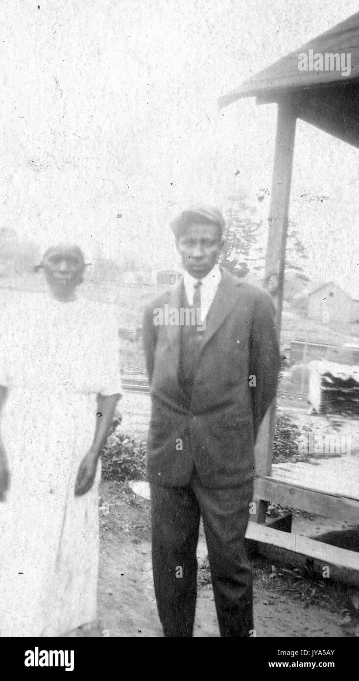 Afrikaner - Mann und Frau, die in der Nähe von der Veranda Ihrer Heimat, im Freien, mit der Mann in Anzug und Hut, die Frau trägt ein weißes Kleid, 1912. Stockfoto