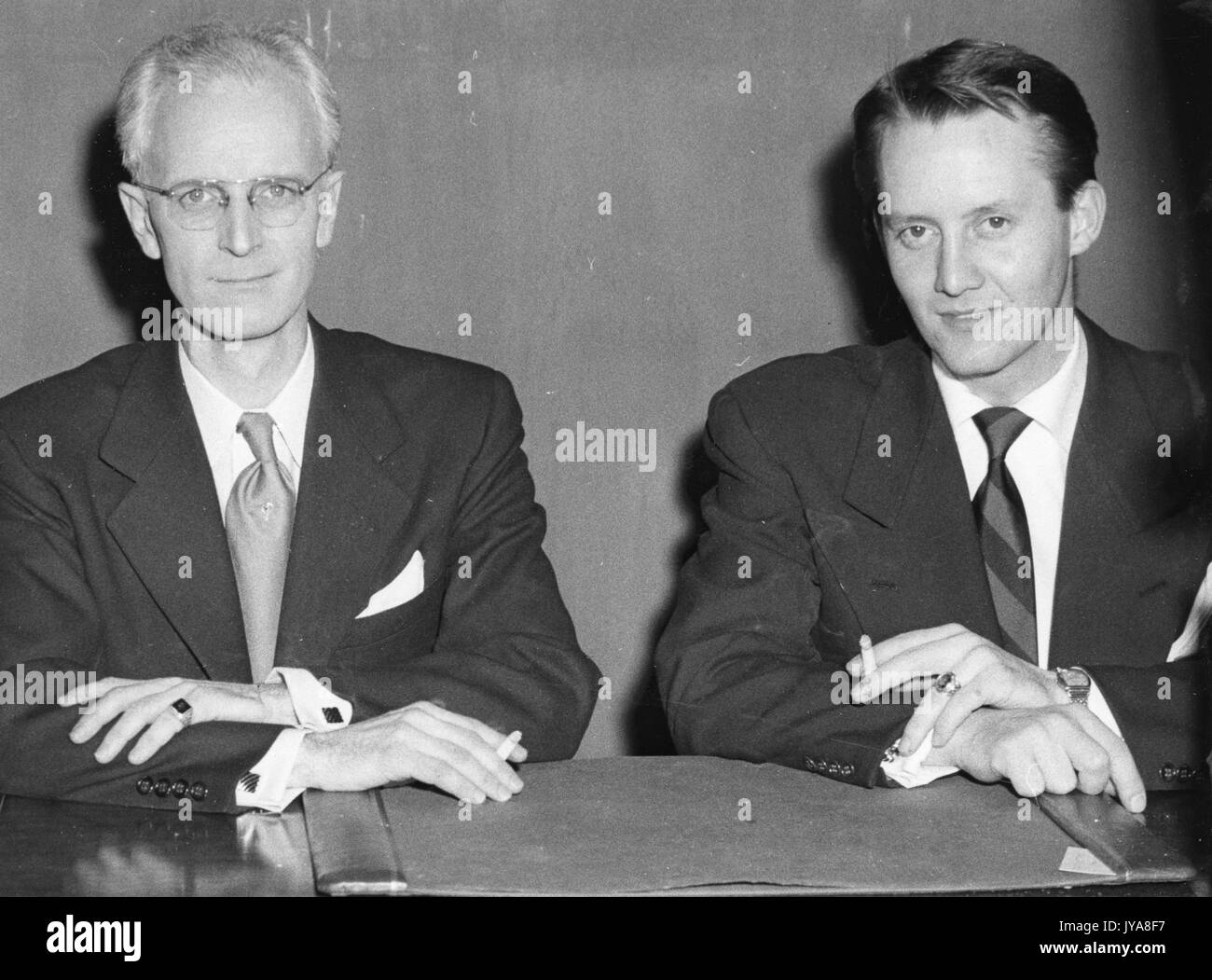 Zwei sitzen rauchende Männer, einer davon ist das amerikanische Fernsehen host Lynn Poole (links), März 1951. Stockfoto