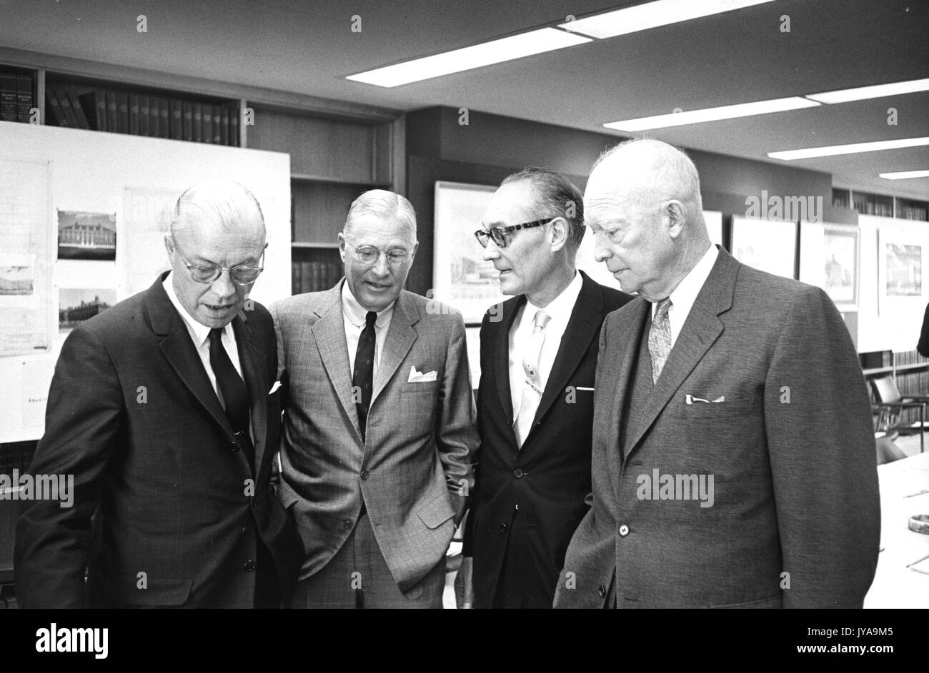 Milton Stover Eisenhower (links), Präsident der Johns Hopkins Universität und Dwight D. Eisenhower (rechts), Präsident der Vereinigten Staaten zu stehen und sich zu unterhalten mit zwei Herren, 1965. Stockfoto