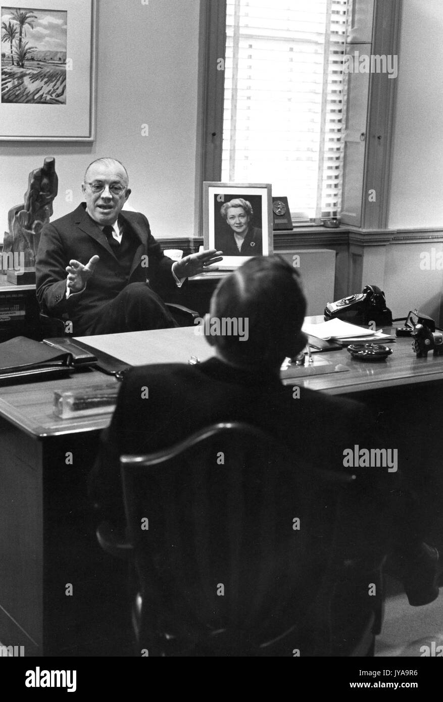 Milton Stover Eisenhower (links), Präsident der Johns Hopkins Universität, saß an seinem Schreibtisch und Sprechen zu einem Gast, Februar, 1962. Stockfoto