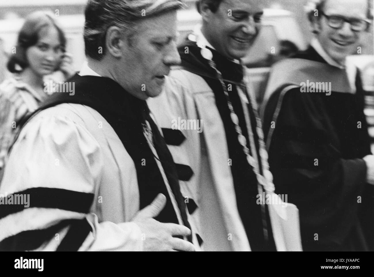 Helmut Schmidt, Bundeskanzler der Bundesrepublik Deutschland, Wandern mit Steven Muller, Präsident der Johns Hopkins Universität, und ein unbekannter Mann, an den Zweihundertsten Einberufung an der Johns Hopkins University Homewood Campus, 16. Juli 1976 statt. Stockfoto