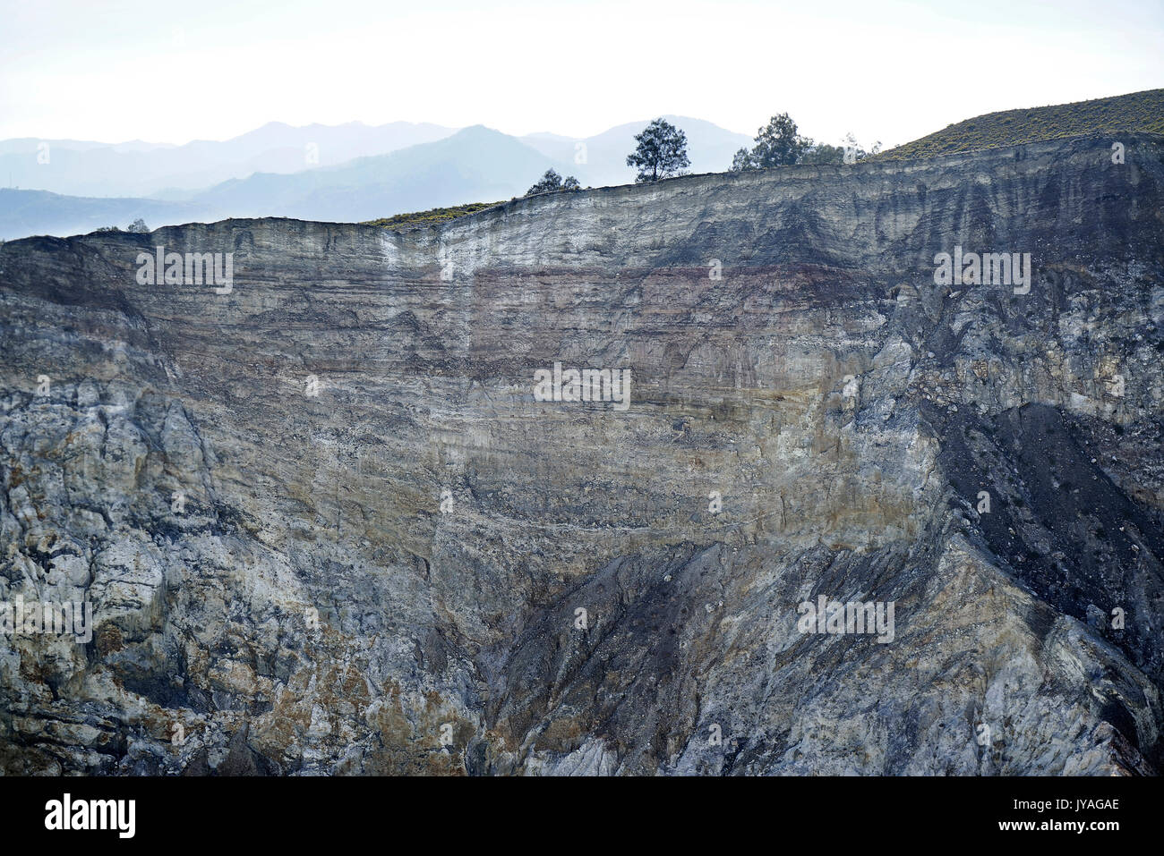 Die Innenwand des Kelimutu Vulkan Krater mit Baum am Rande während des Morgens bei Sonnenaufgang mit niemand um, Indonesien. Stockfoto