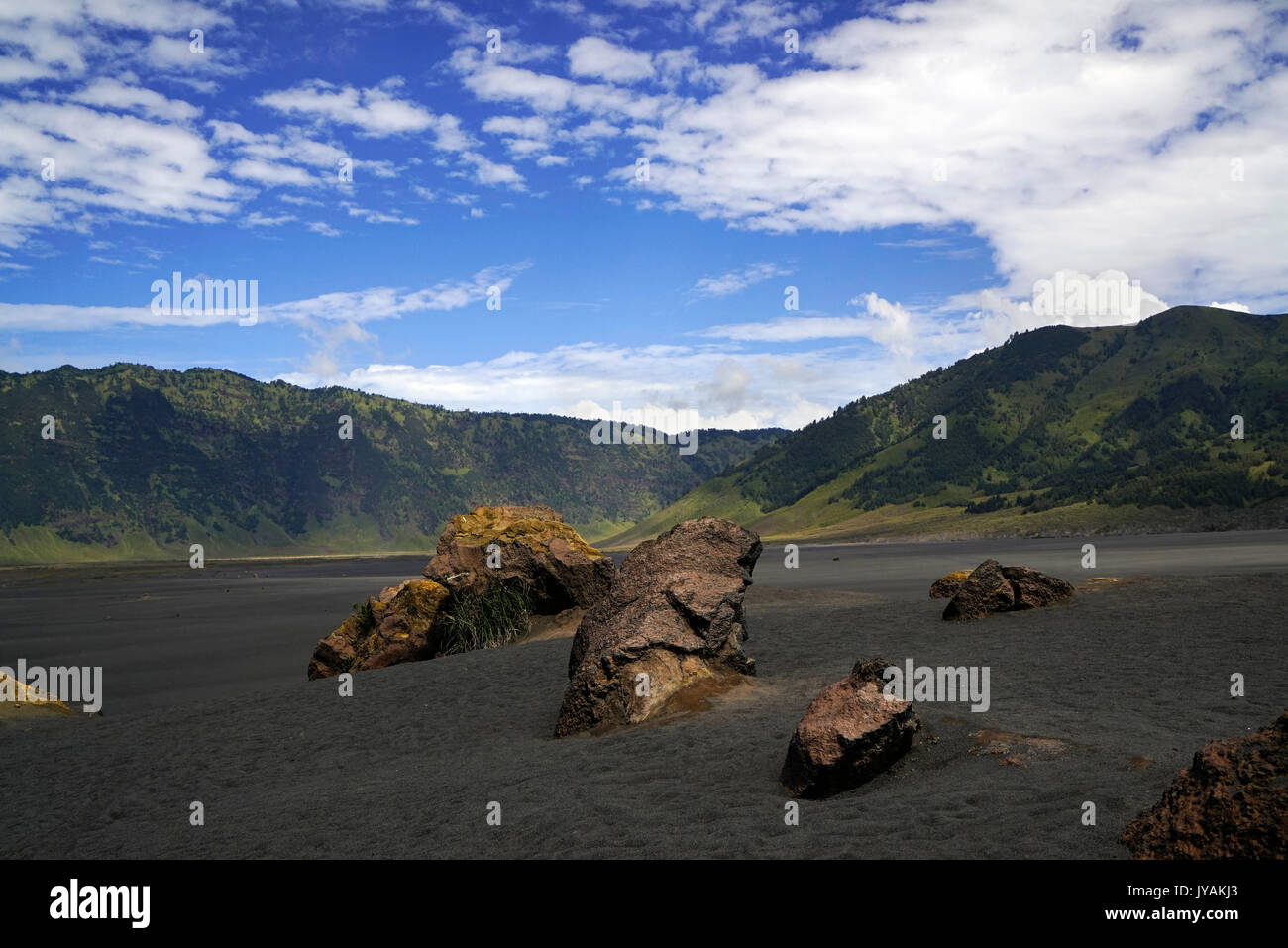 Sand Sea in bromo Tal mit Bergen im Hintergrund und blauen Himmel am Morgen an der Tengger Semeru National Park in Ostjava, Indonesien. Stockfoto