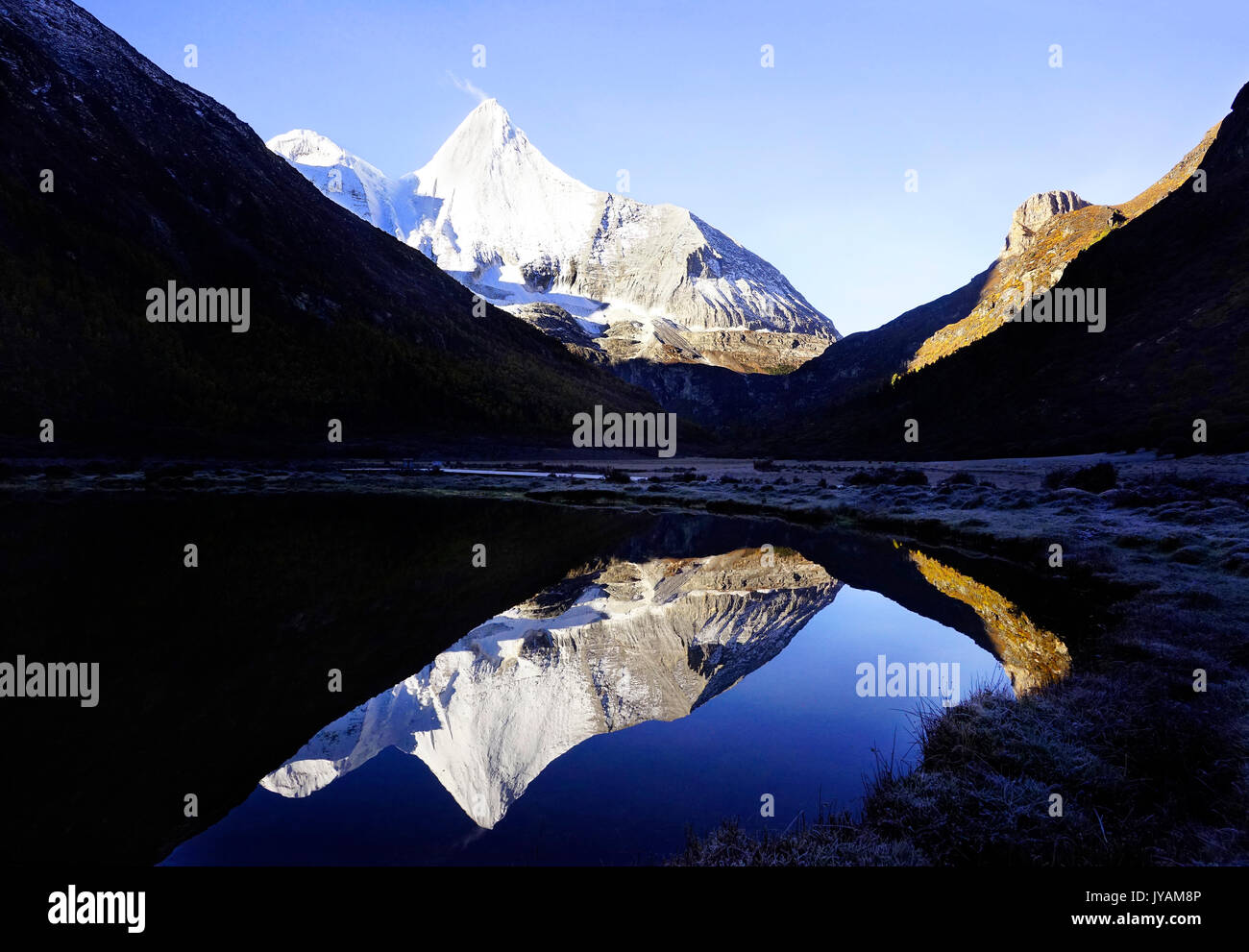 Shangri La, Blick auf die Heiligen schneebedeckten Berg Jambeyang und seinen See Reflexion in Yading nationaler Ebene finden, Daocheng, Provinz Sichuan, China. Stockfoto