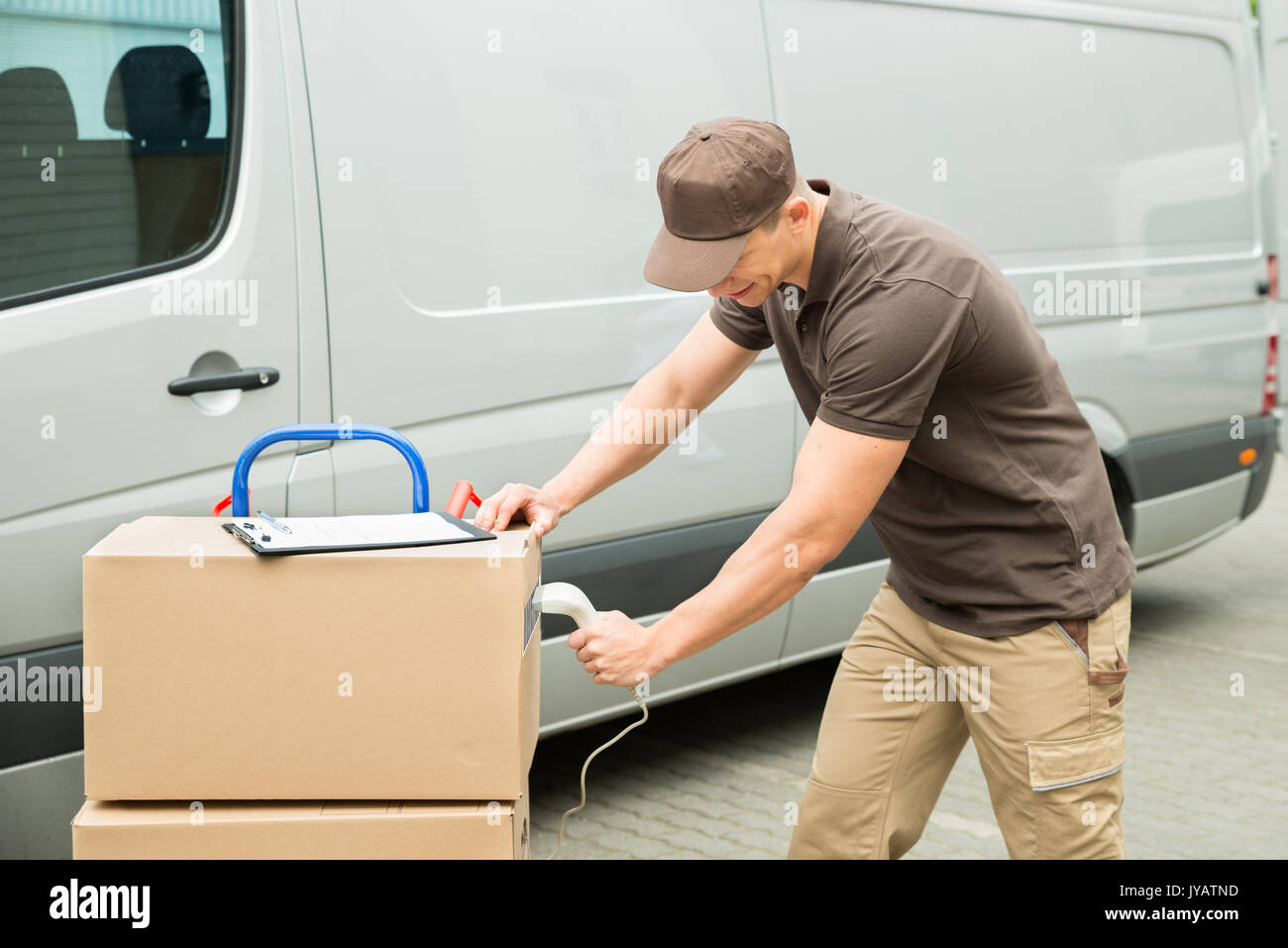 Junge Delivery Man Scannen Kartons mit Barcode Scanner Stockfoto