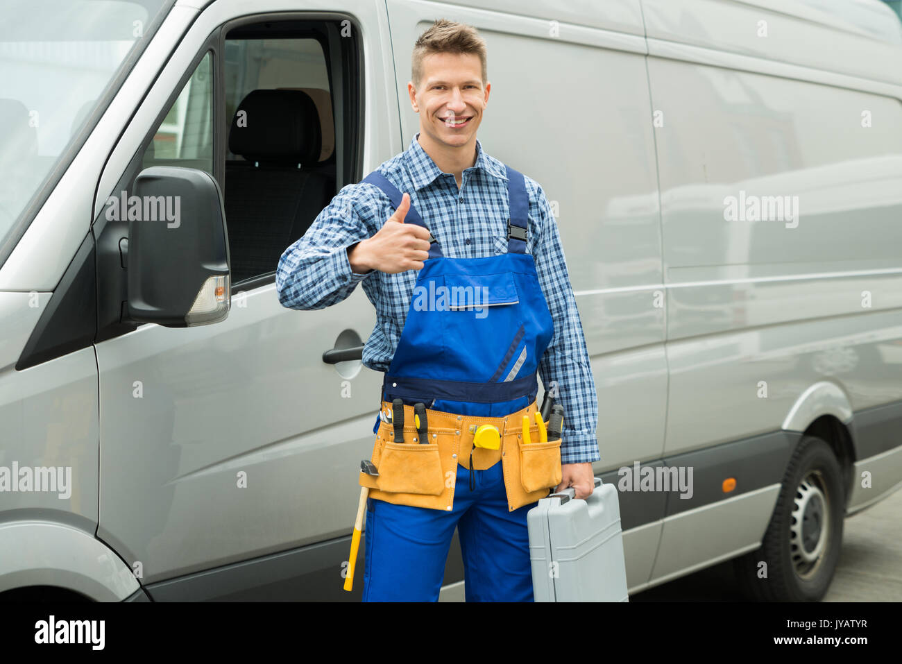 Gerne Handwerker mit Werkzeugen und Toolbox angezeigt "Daumen hoch"-Zeichen vor der Van Stockfoto