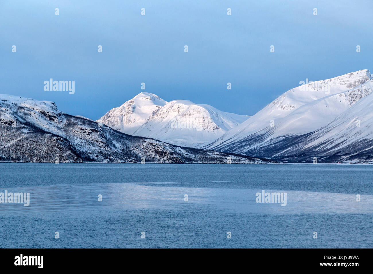Blauer Himmel und schneebedeckten Gipfeln umgeben das kalte Meer Lyngen Alpen Tromsø Lappland Norwegen Europa Stockfoto