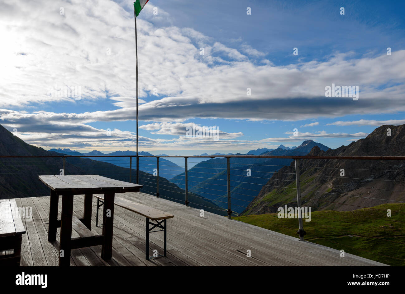 Tisch und Bank aus Holz auf der Terrasse mit schöner Aussicht über die Berge Stockfoto