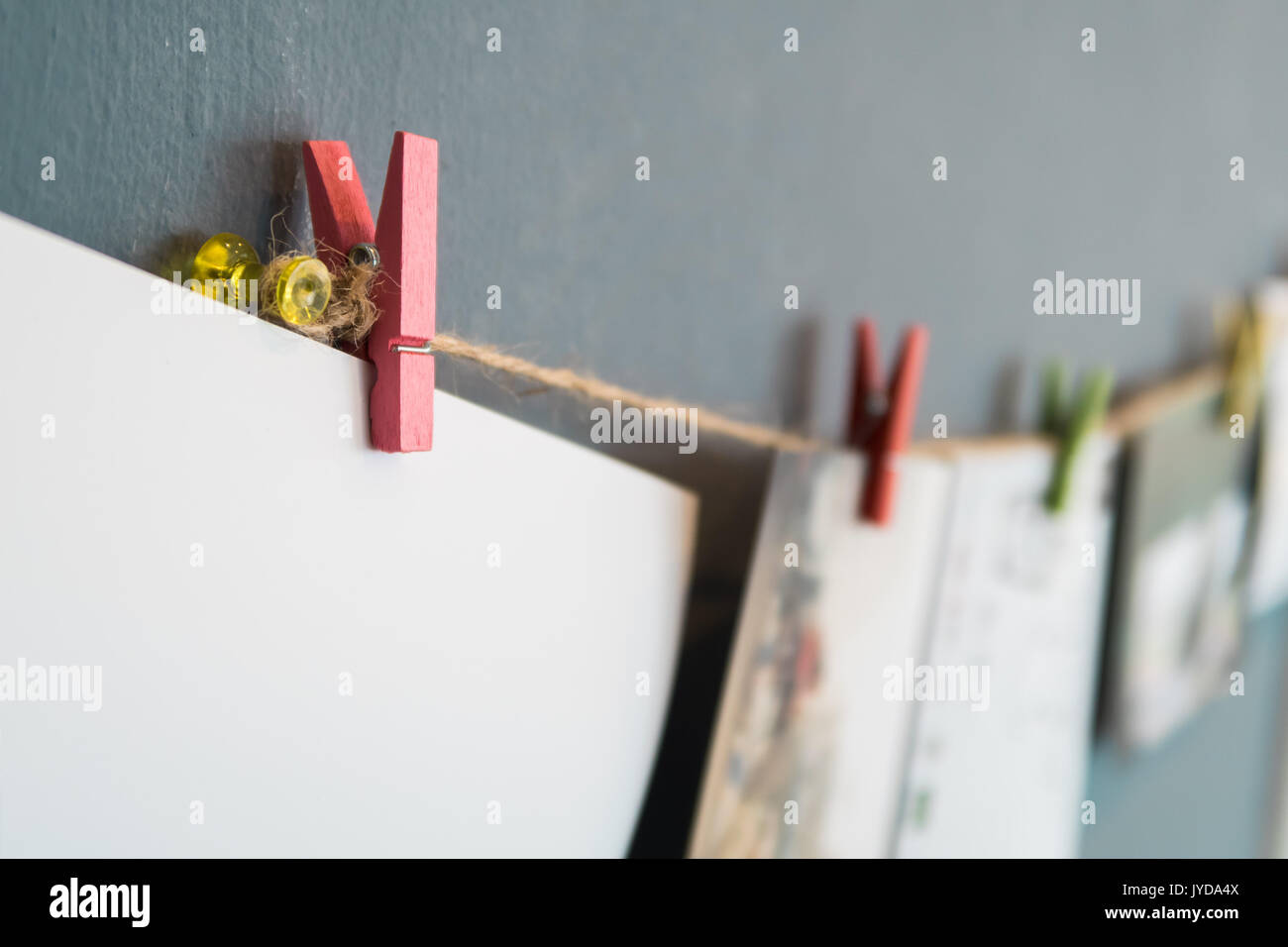Leeres weißes Papier hängen mit clothpeg auf graue Wand Stockfoto