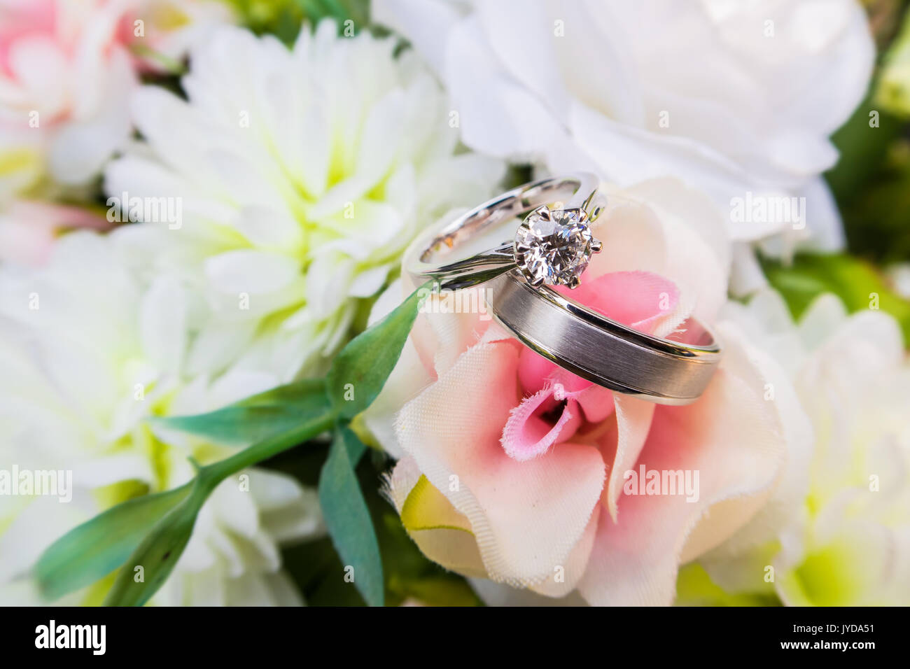 Zwei Trauringe auf Blumenstrauß Stockfoto